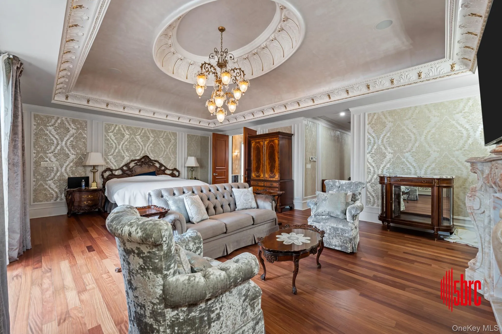 Bedroom with a raised ceiling, wood finished floors, a chandelier, and ornamental molding Bedroom with a raised ceiling, wood finished floors, a chandelier, and ornamental molding