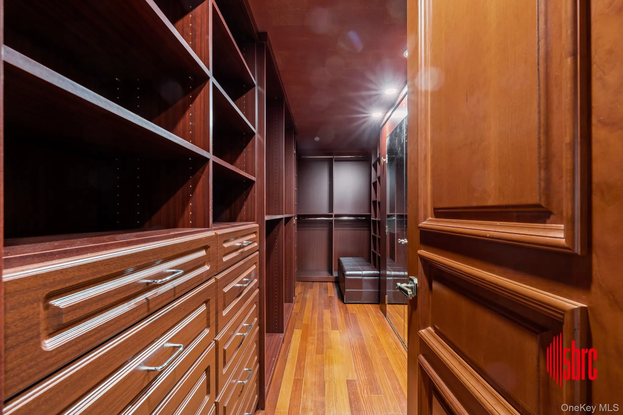 Walk in closet with light wood-style flooring Walk in closet with light wood-style flooring