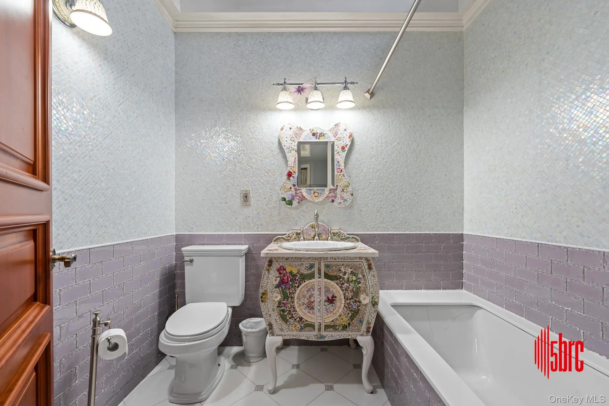 Full bath with tile walls, a garden tub, vanity, wainscoting, and tile patterned floors Full bath with tile walls, a garden tub, vanity, wainscoting, and tile patterned floors