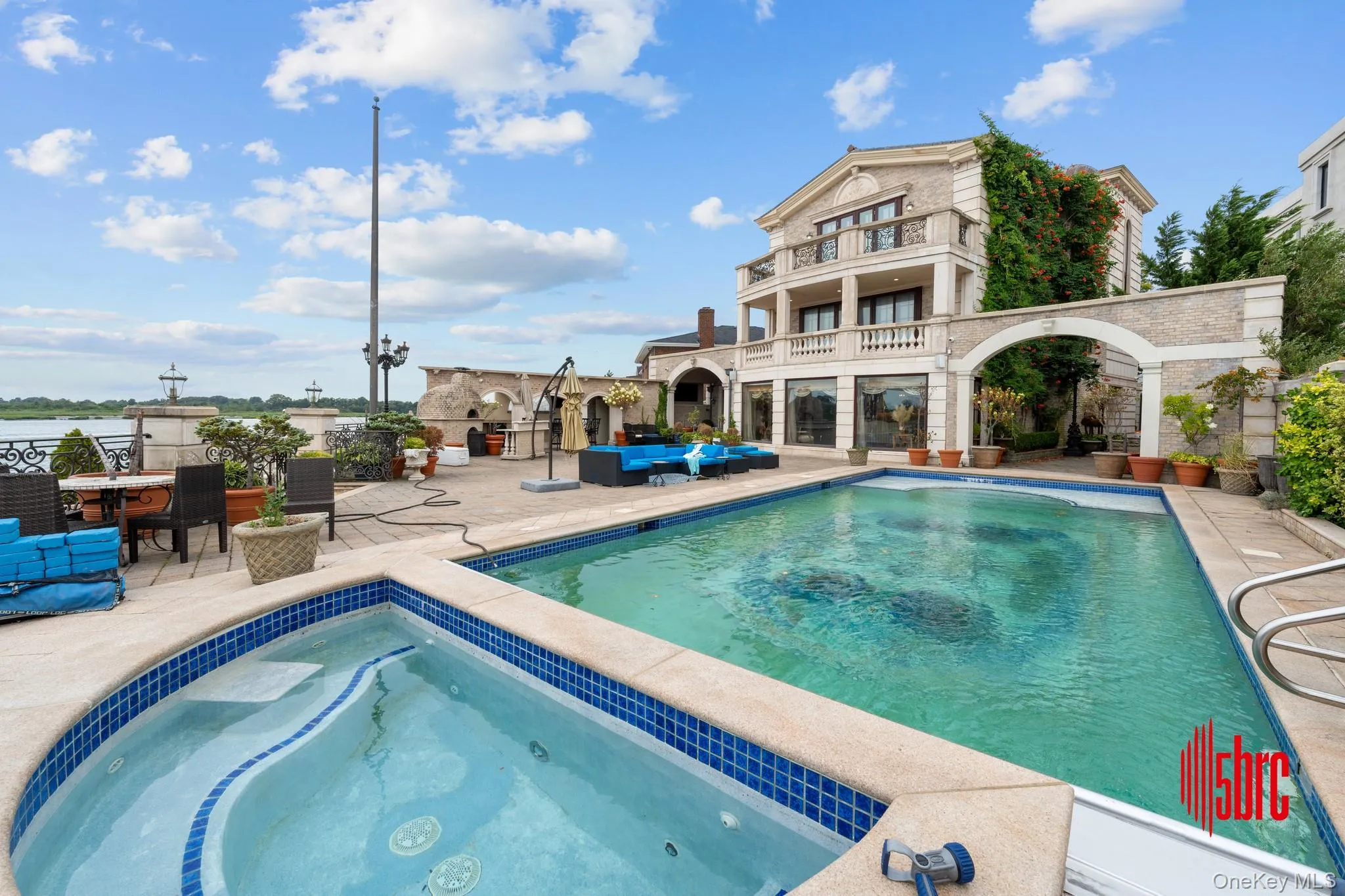 Outdoor pool with a balcony, a patio, an in-ground hot tub, and outdoor lounge area Outdoor pool with a balcony, a patio, an in-ground hot tub, and outdoor lounge area