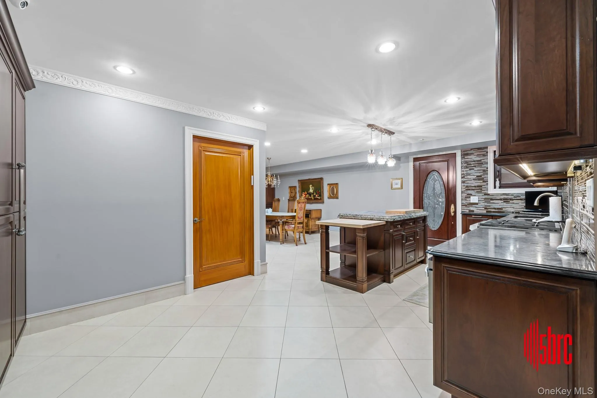 Kitchen featuring dark brown cabinets, decorative light fixtures, open shelves, light tile patterned floors, and recessed lighting Kitchen featuring dark brown cabinets, decorative light fixtures, open shelves, light tile patterned floors, and recessed lighting