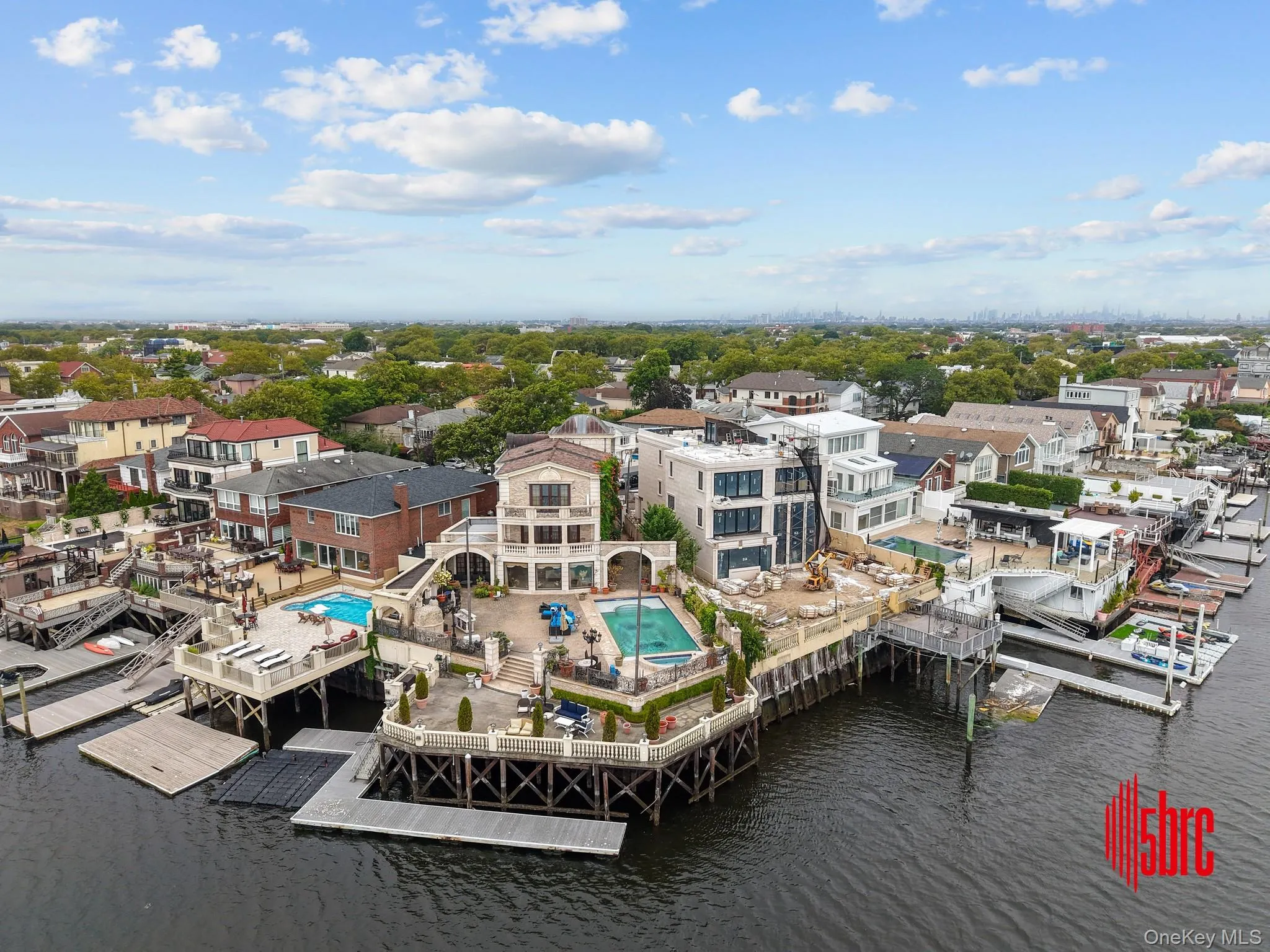 Aerial perspective of suburban area with a nearby body of water and a pool area Aerial perspective of suburban area with a nearby body of water and a pool area
