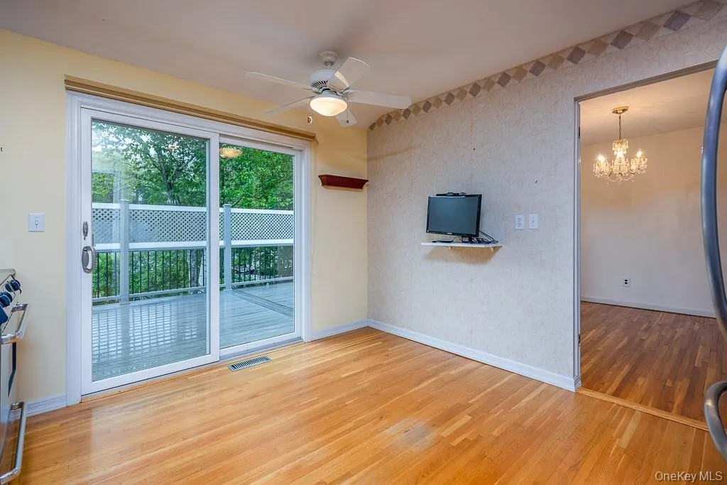 Unfurnished living room featuring baseboards, wood finished floors, a chandelier, and a ceiling fan Unfurnished living room featuring baseboards, wood finished floors, a chandelier, and a ceiling fan