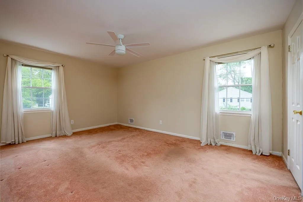 Spare room featuring plenty of natural light, ceiling fan, and carpet flooring Spare room featuring plenty of natural light, ceiling fan, and carpet flooring