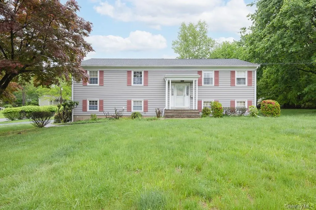 Split foyer home featuring a front yard Split foyer home featuring a front yard