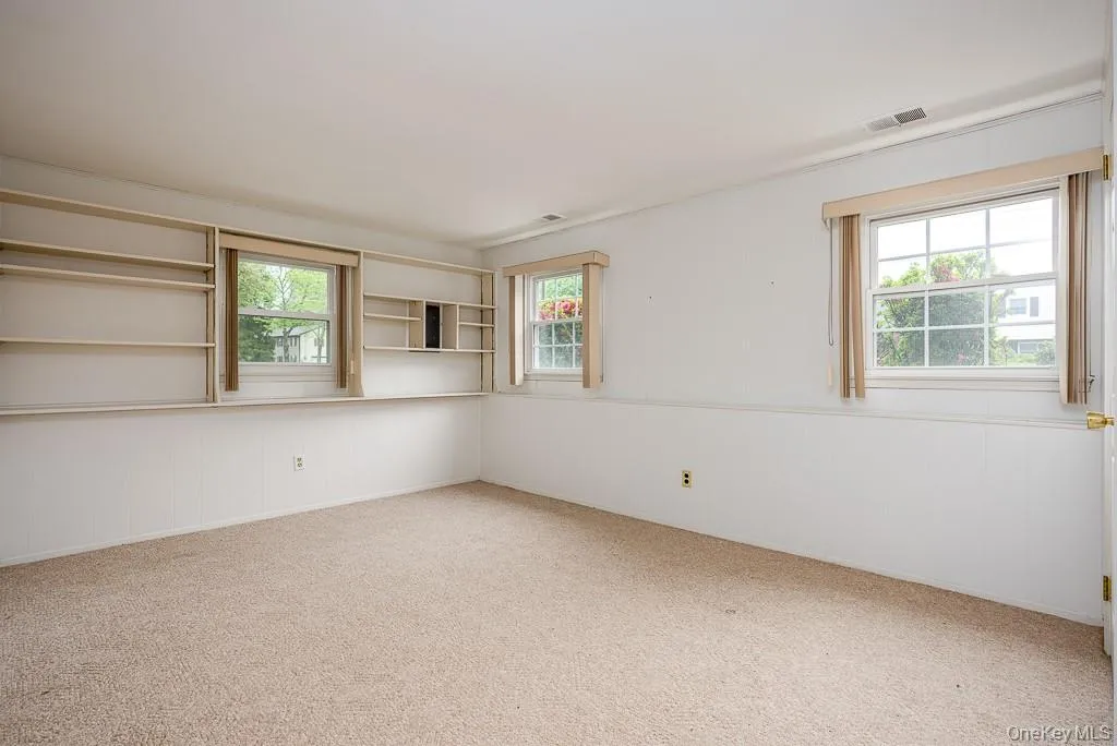 Empty room with plenty of natural light and carpet floors Empty room with plenty of natural light and carpet floors