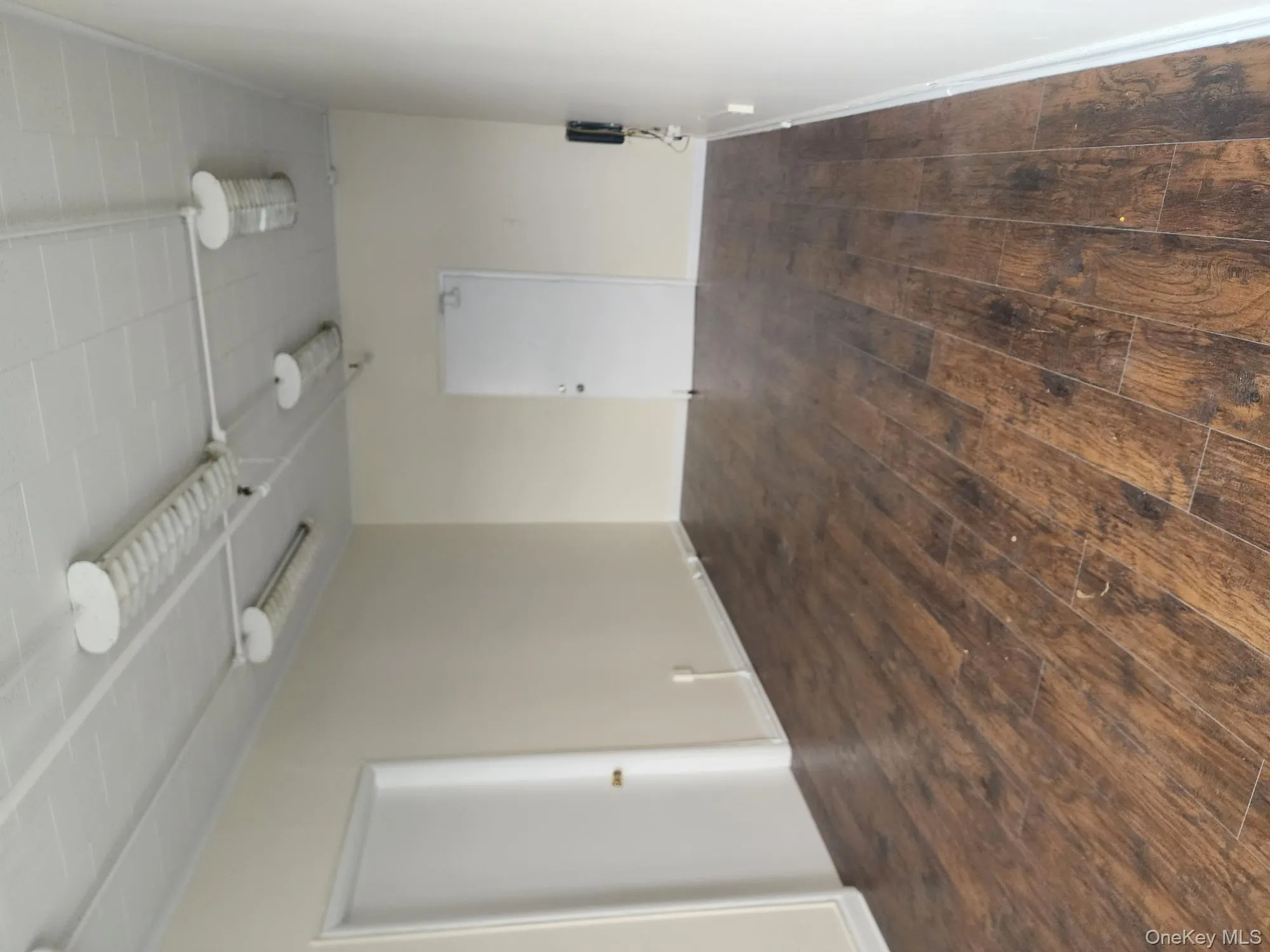 Empty room with dark wood-type flooring and baseboards Empty room with dark wood-type flooring and baseboards