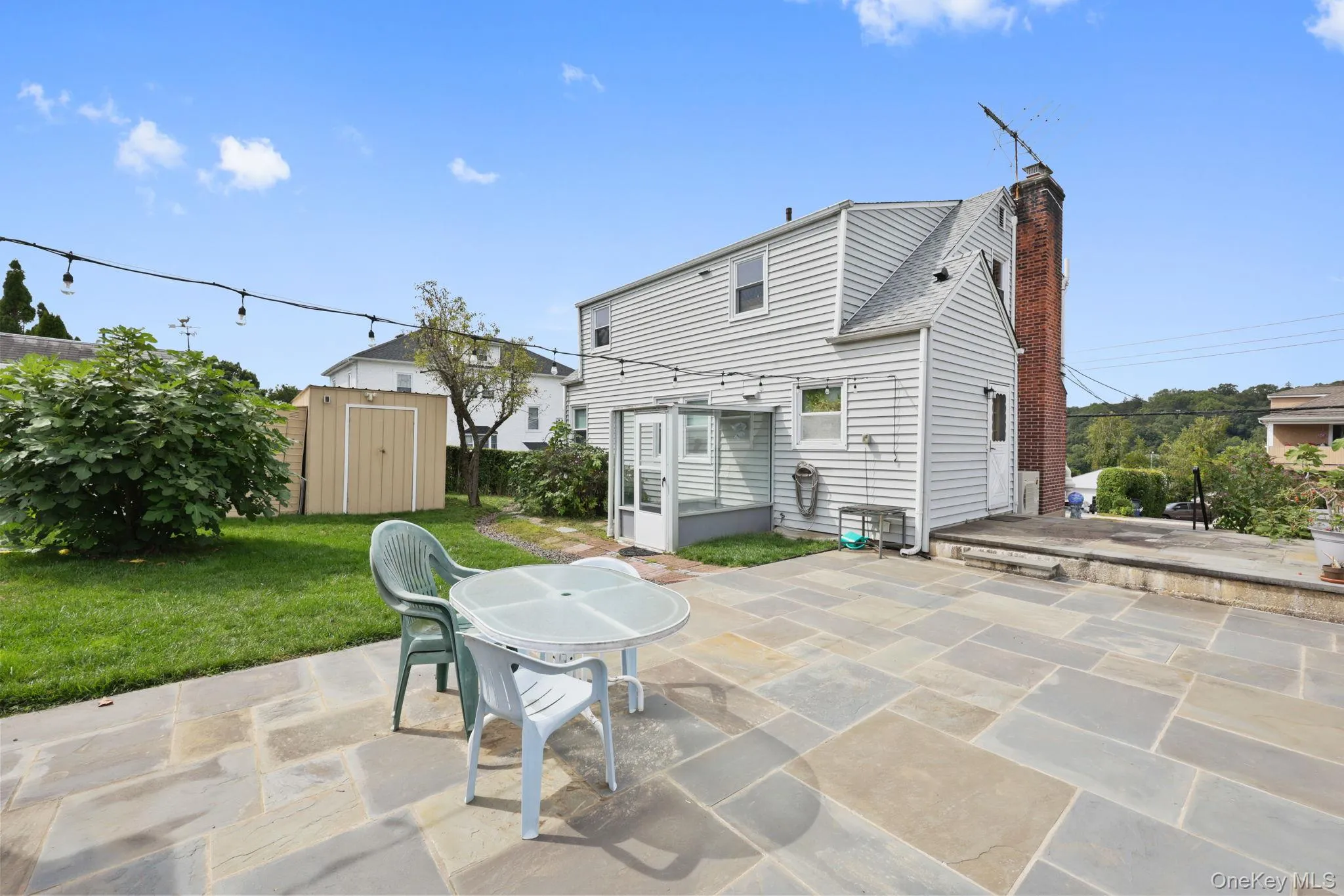 Rear view of property featuring a patio area, a chimney, and a shed Rear view of property featuring a patio area, a chimney, and a shed