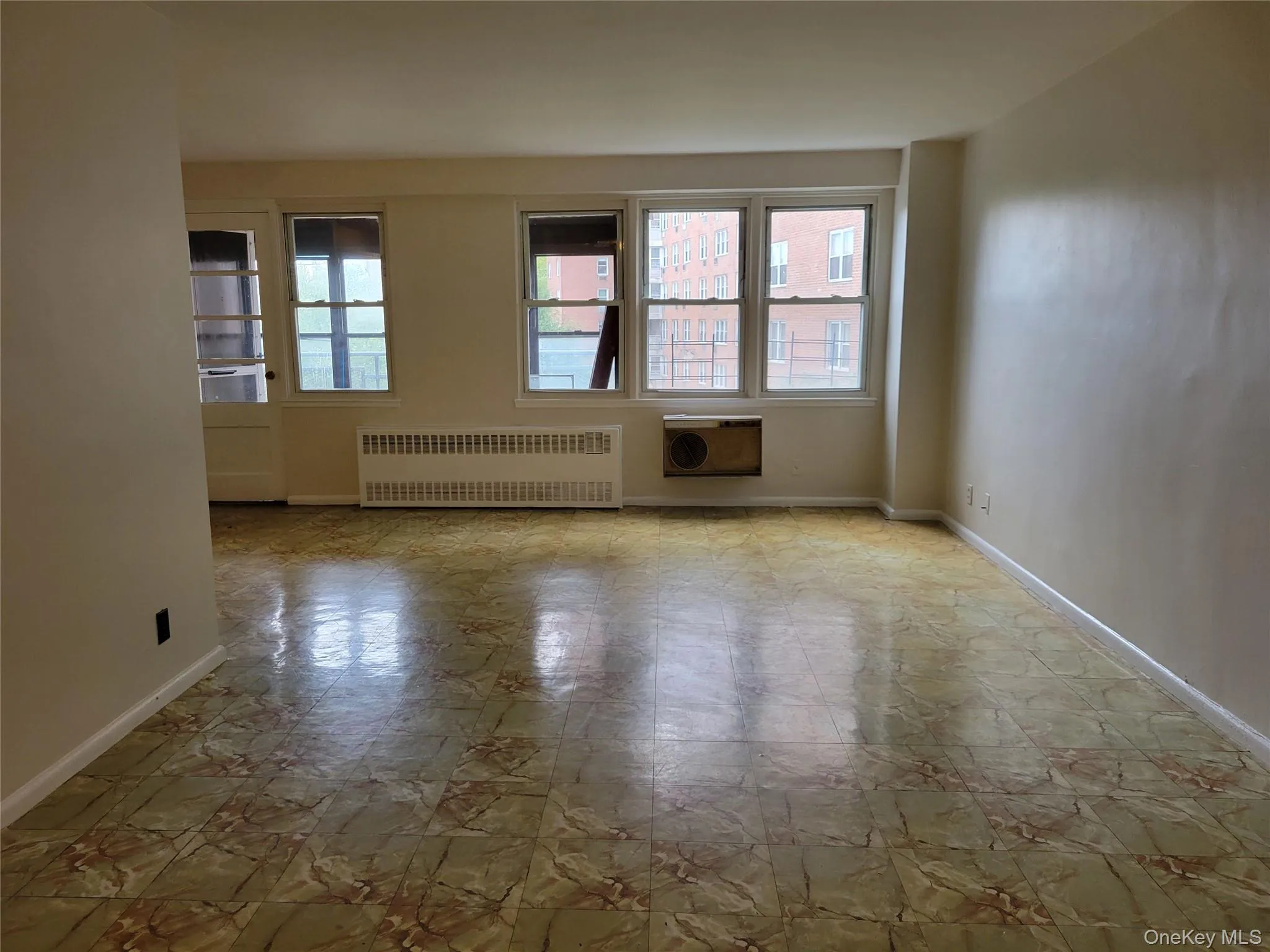 Spare room featuring radiator heating unit and baseboards Spare room featuring radiator heating unit and baseboards