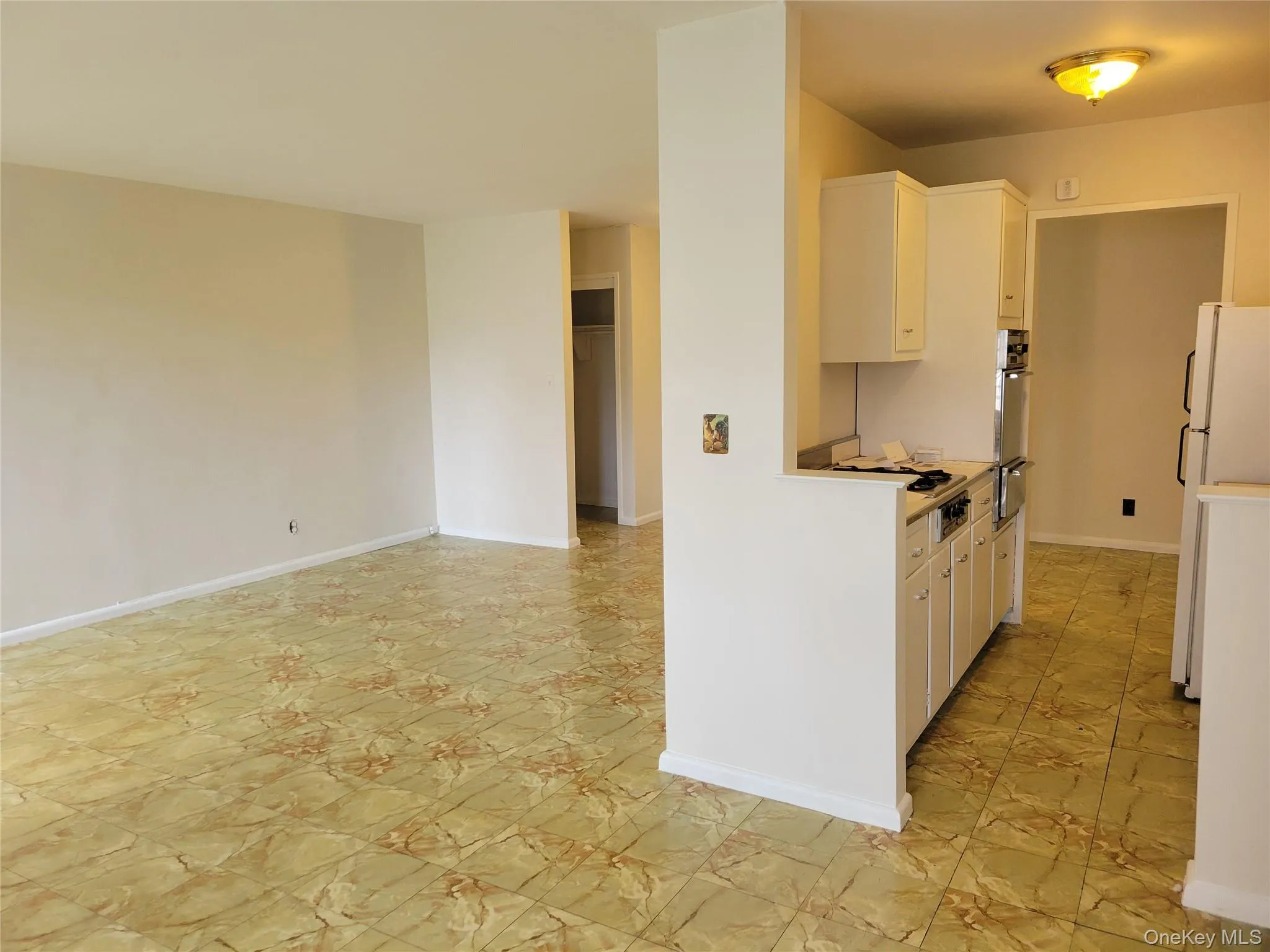 Kitchen featuring freestanding refrigerator, light countertops, white cabinetry, stainless steel oven, and gas stovetop Kitchen featuring freestanding refrigerator, light countertops, white cabinetry, stainless steel oven, and gas stovetop