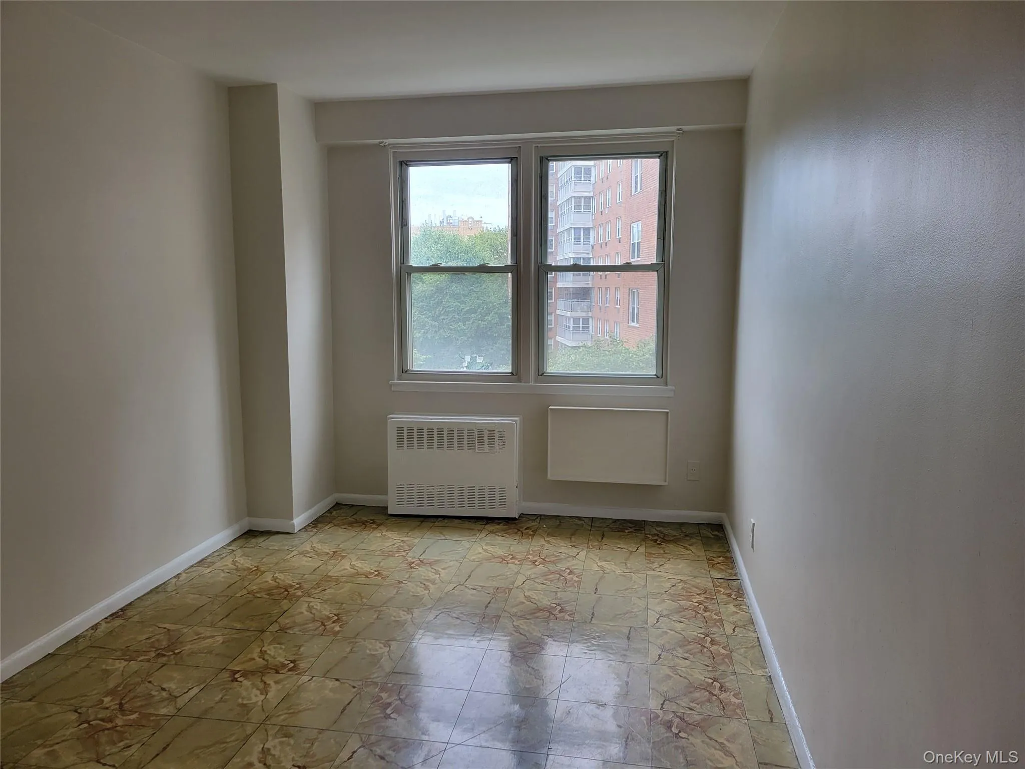 Spare room featuring radiator and baseboards Spare room featuring radiator and baseboards