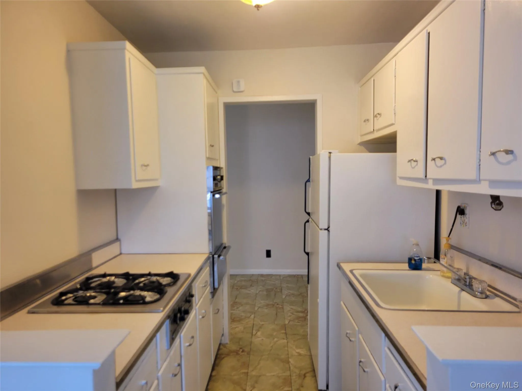 Kitchen featuring white cabinetry, white appliances, light countertops, and a warming drawer Kitchen featuring white cabinetry, white appliances, light countertops, and a warming drawer