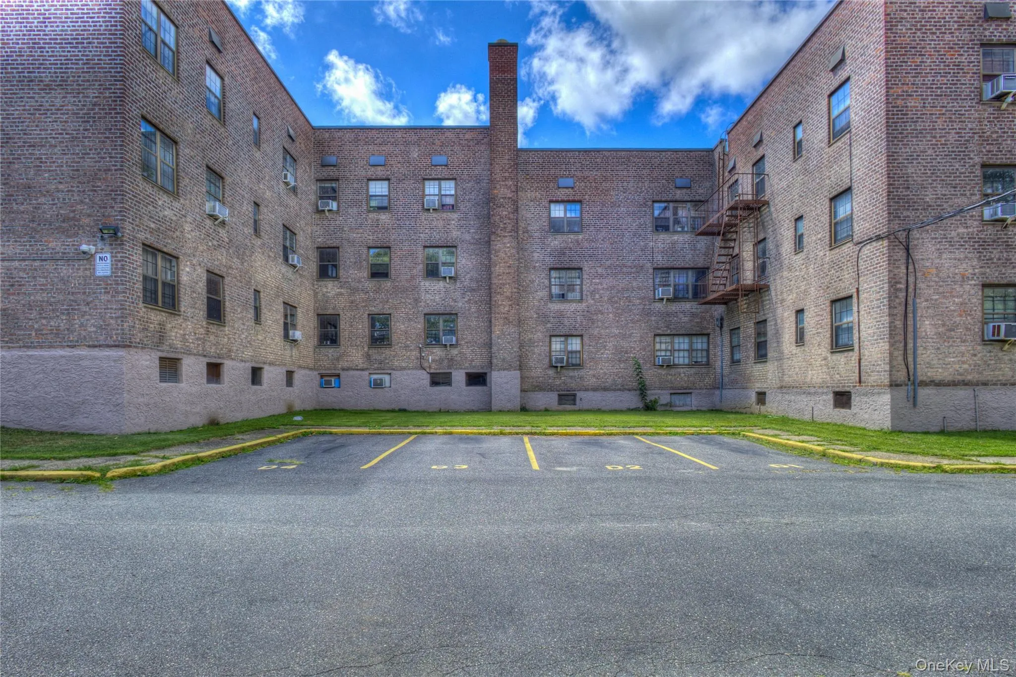 View of apartment building / complex featuring uncovered parking View of apartment building / complex featuring uncovered parking