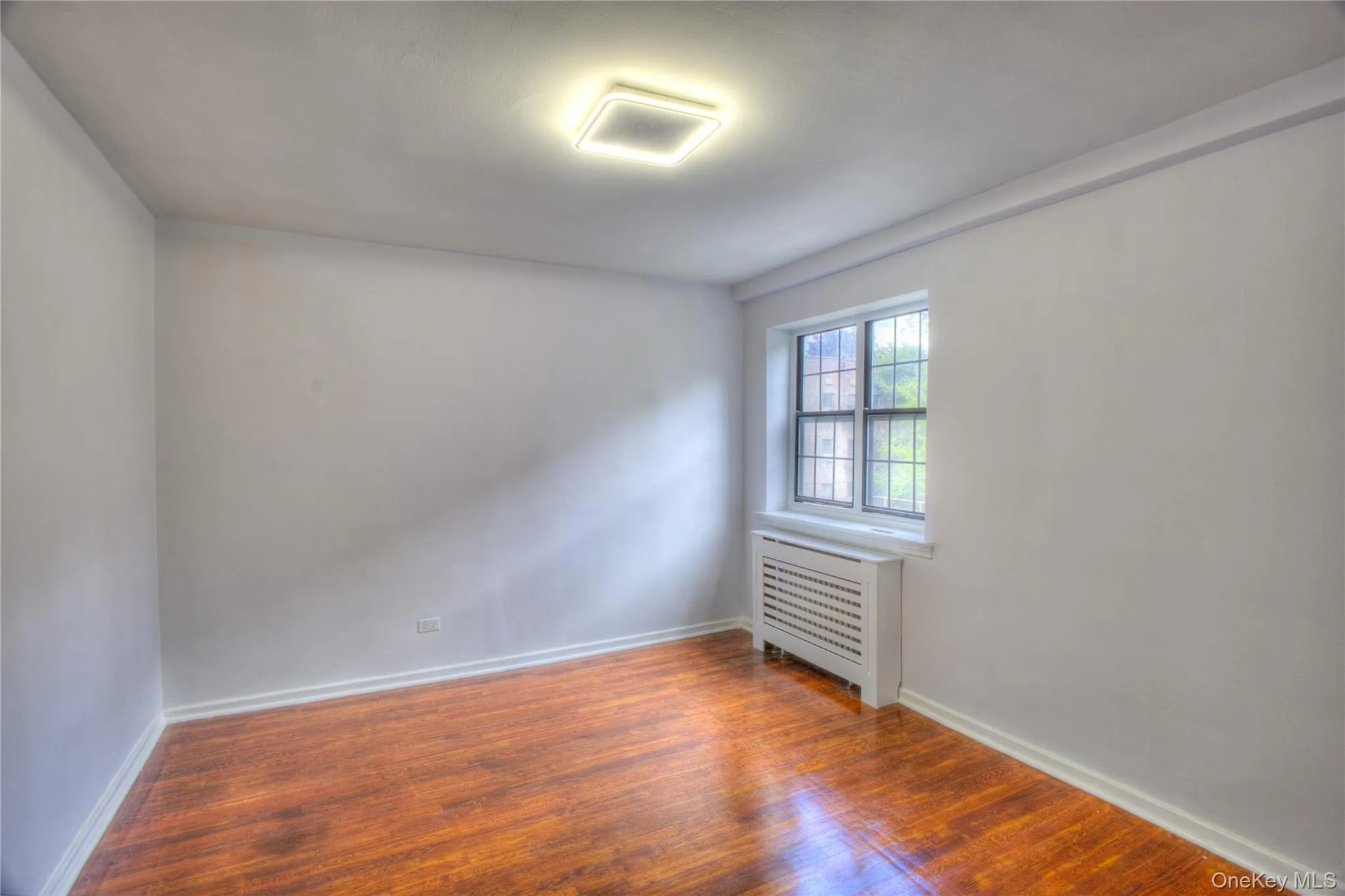 Empty room with radiator and wood finished floors Empty room with radiator and wood finished floors