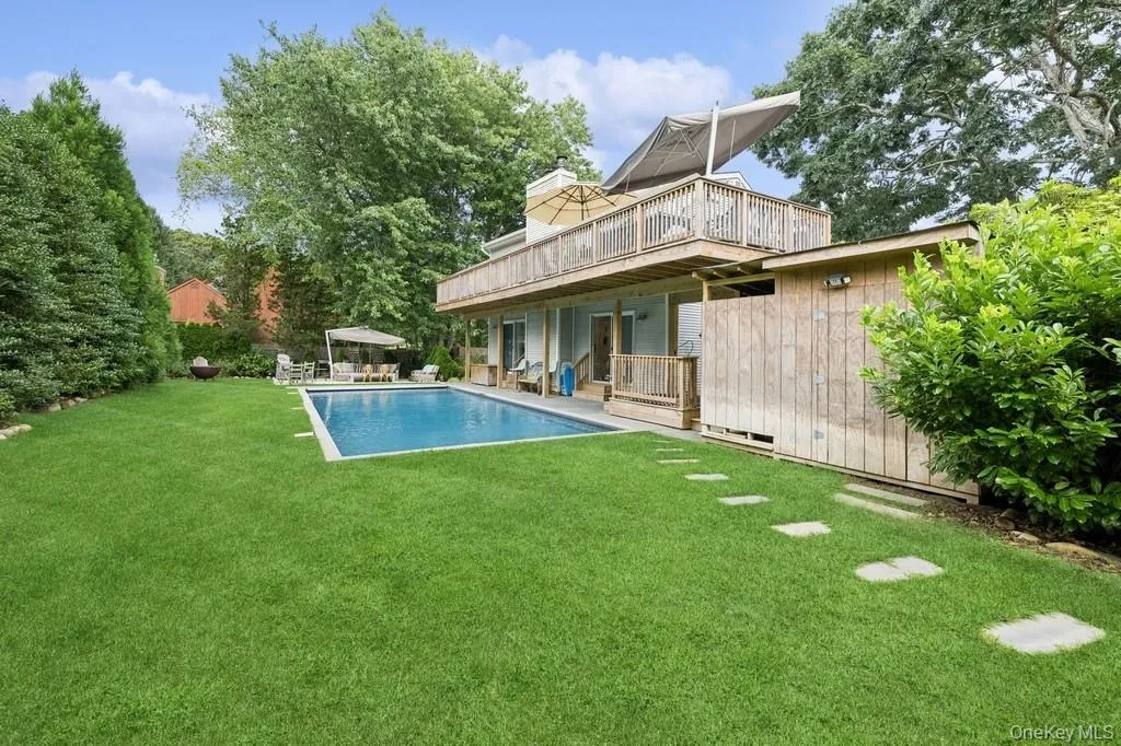 Back of house with a patio area, a yard, crawl space, a chimney, and an outdoor pool Back of house with a patio area, a yard, crawl space, a chimney, and an outdoor pool