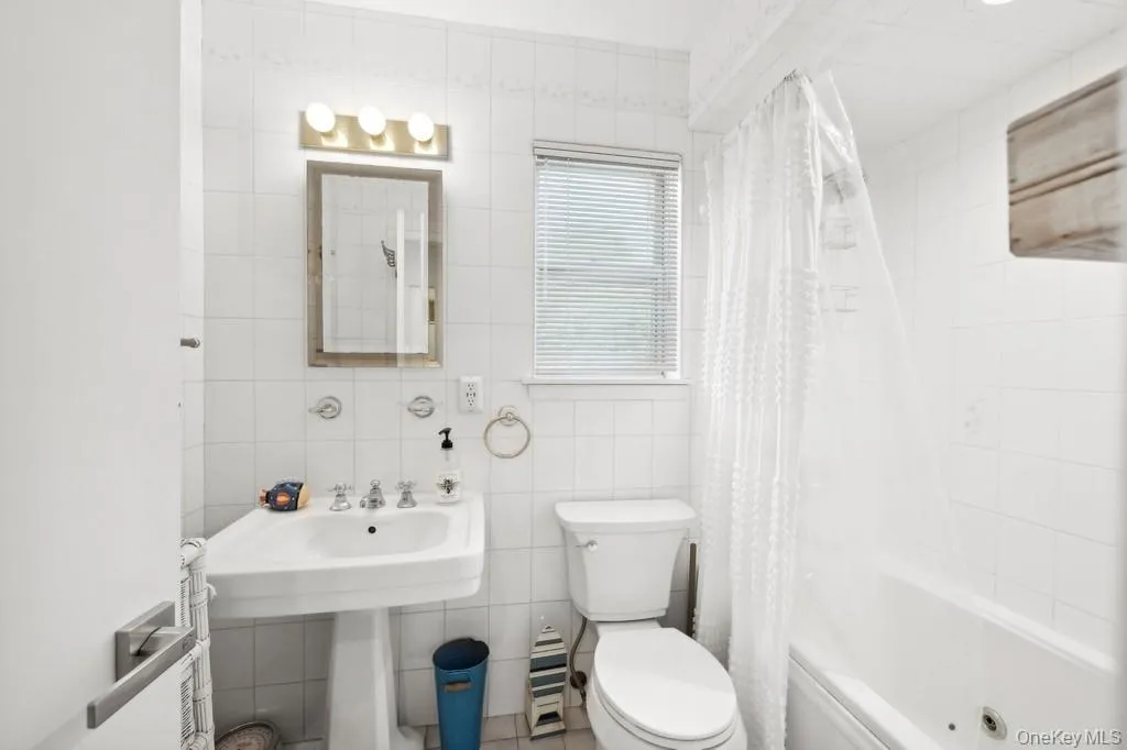 Bathroom with tile walls and shower / bath combination with curtain Bathroom with tile walls and shower / bath combination with curtain