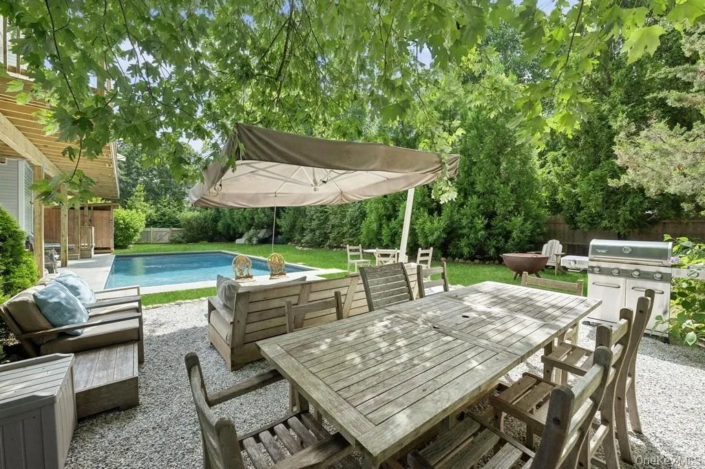 Fenced backyard featuring a patio, outdoor dining area, view of scattered trees, and outdoor lounge area Fenced backyard featuring a patio, outdoor dining area, view of scattered trees, and outdoor lounge area