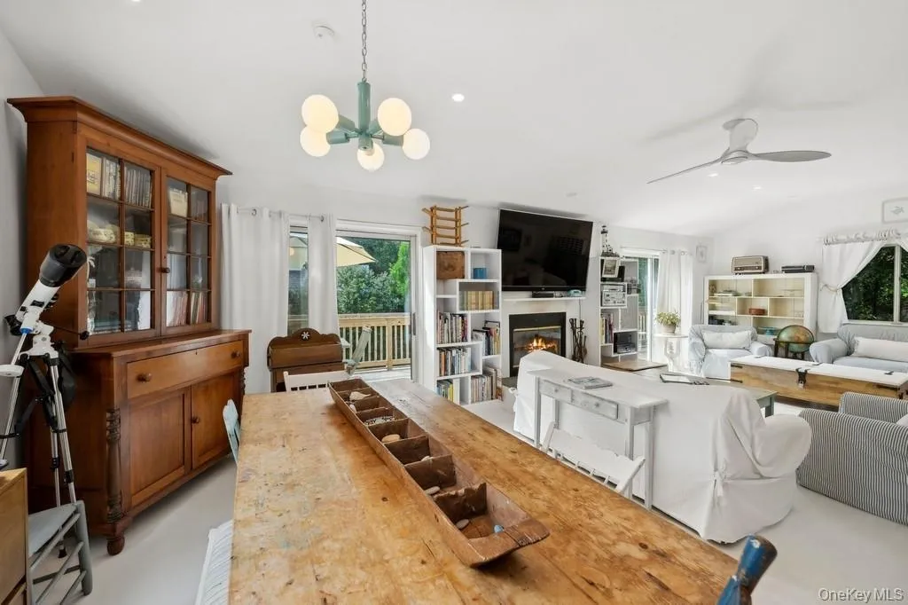 Dining room with a glass covered fireplace, ceiling fan, recessed lighting, and a chandelier Dining room with a glass covered fireplace, ceiling fan, recessed lighting, and a chandelier