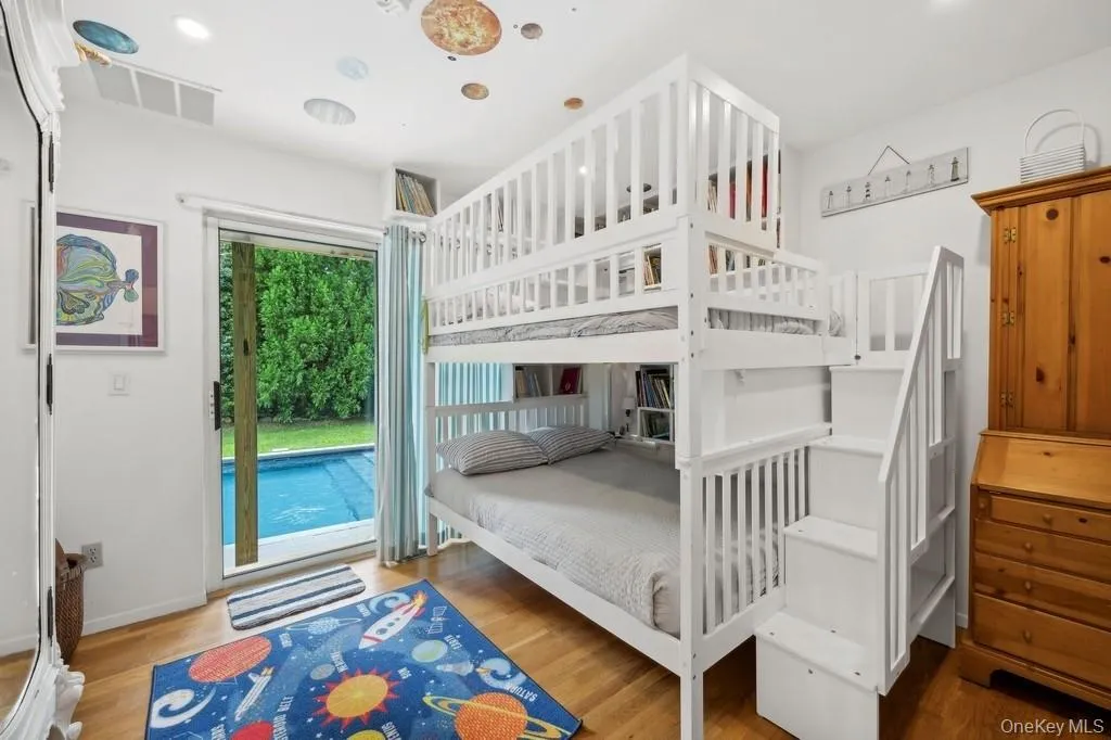 Bedroom featuring wood finished floors, access to exterior, and recessed lighting Bedroom featuring wood finished floors, access to exterior, and recessed lighting