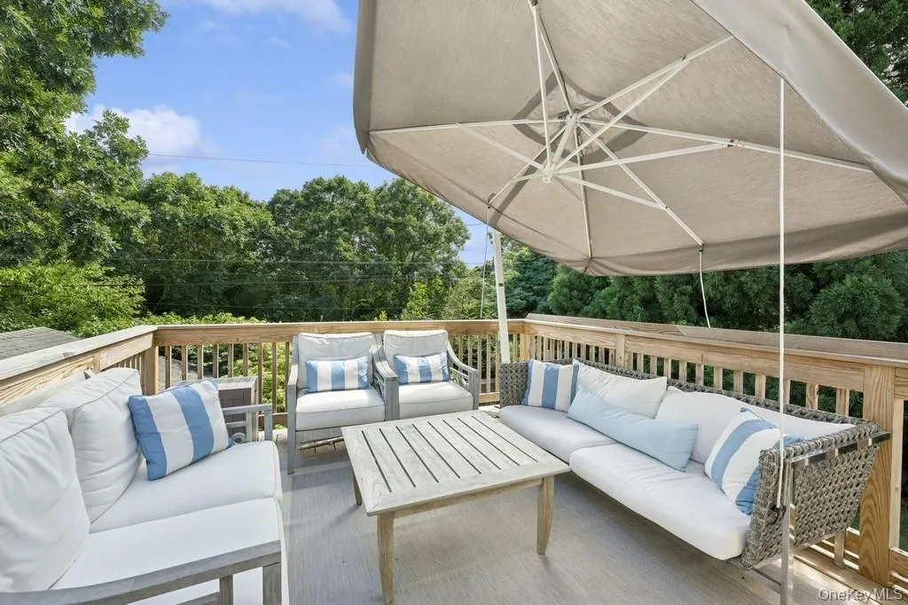 Wooden terrace with outdoor lounge area and view of scattered trees Wooden terrace with outdoor lounge area and view of scattered trees