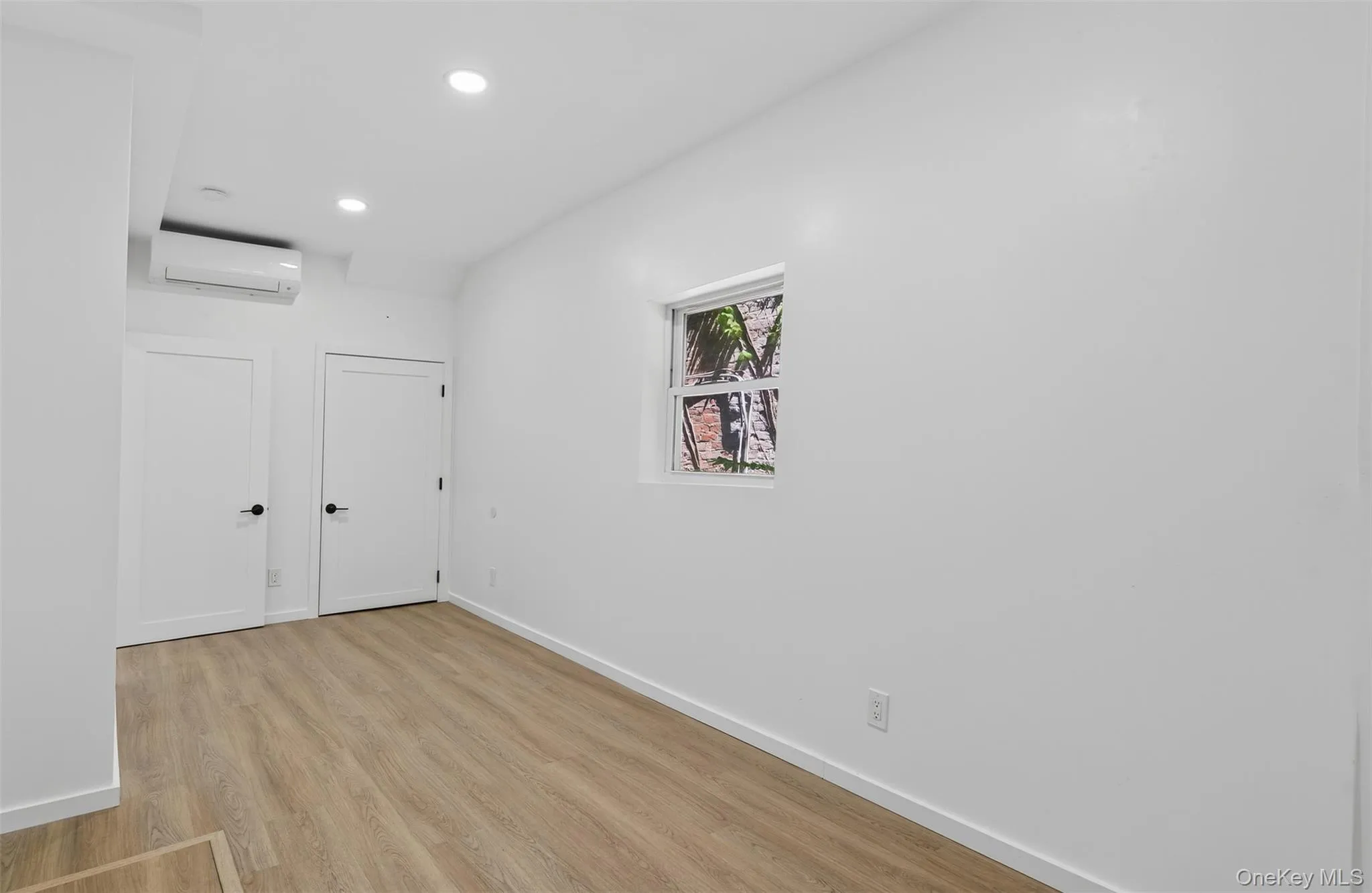 Spare room with light wood-type flooring, recessed lighting, and a wall unit AC Spare room with light wood-type flooring, recessed lighting, and a wall unit AC