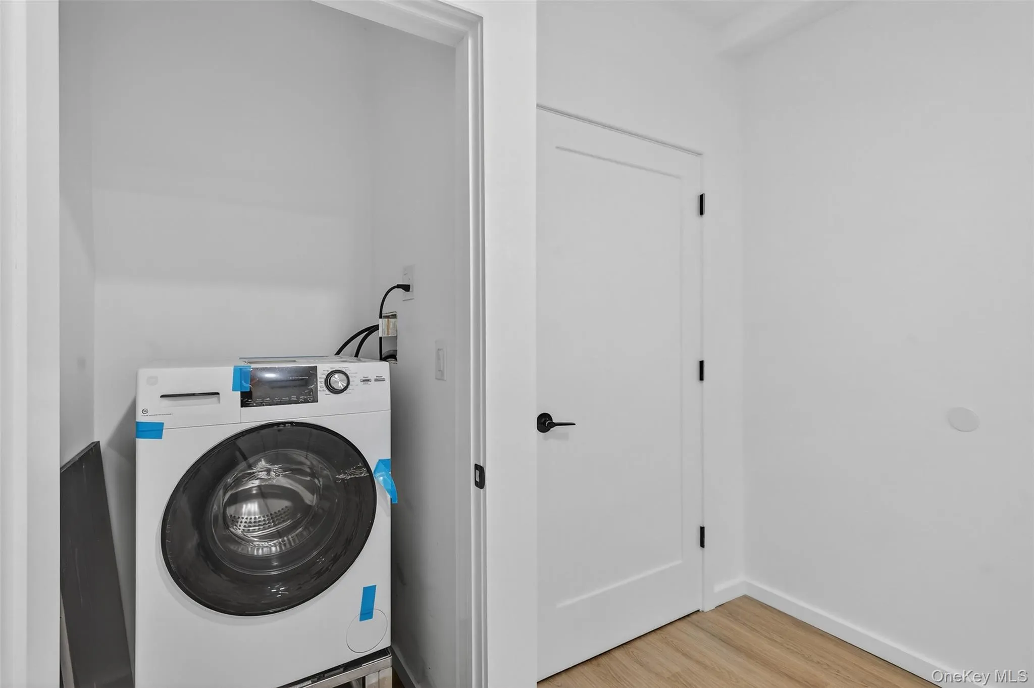 Laundry area featuring washer / clothes dryer and light wood-style flooring Laundry area featuring washer / clothes dryer and light wood-style flooring
