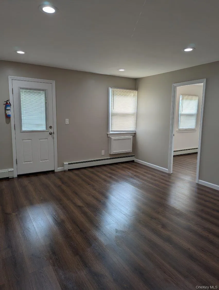 Foyer entrance with dark wood finished floors, a baseboard heating unit, and recessed lighting Foyer entrance with dark wood finished floors, a baseboard heating unit, and recessed lighting