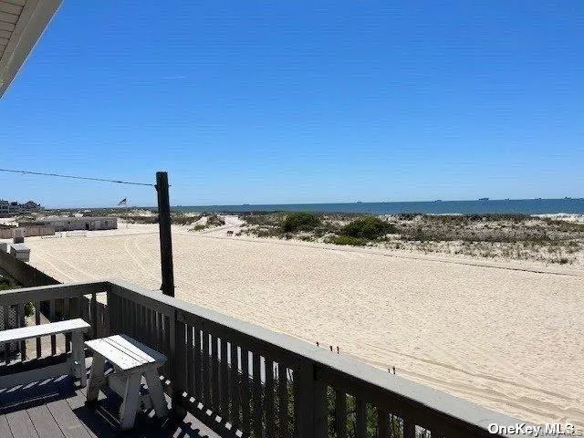Wooden terrace featuring view of water and beach Wooden terrace featuring view of water and beach