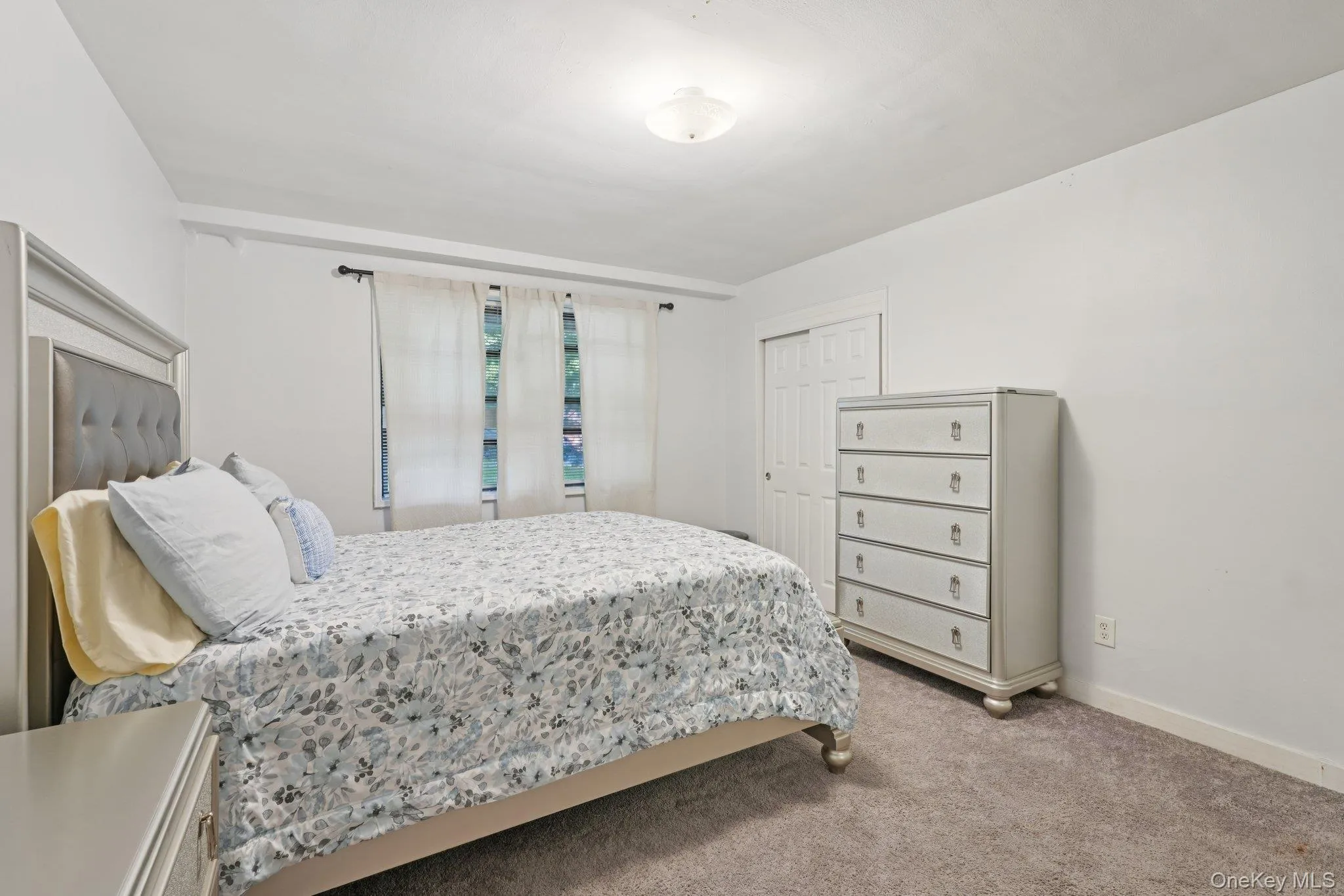 Carpeted bedroom with baseboards and a closet Carpeted bedroom with baseboards and a closet