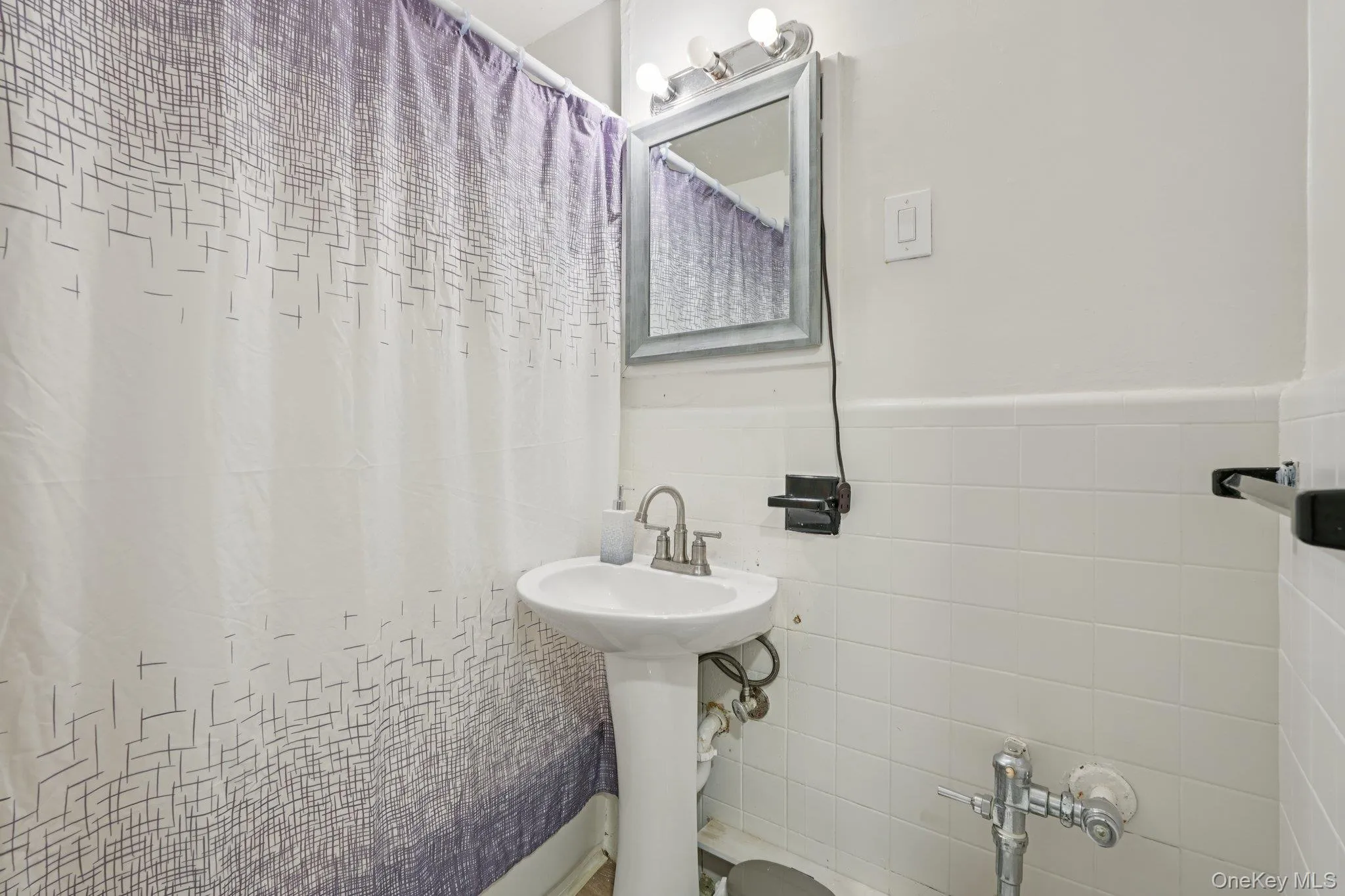 Bathroom with tile walls and a shower with curtain Bathroom with tile walls and a shower with curtain