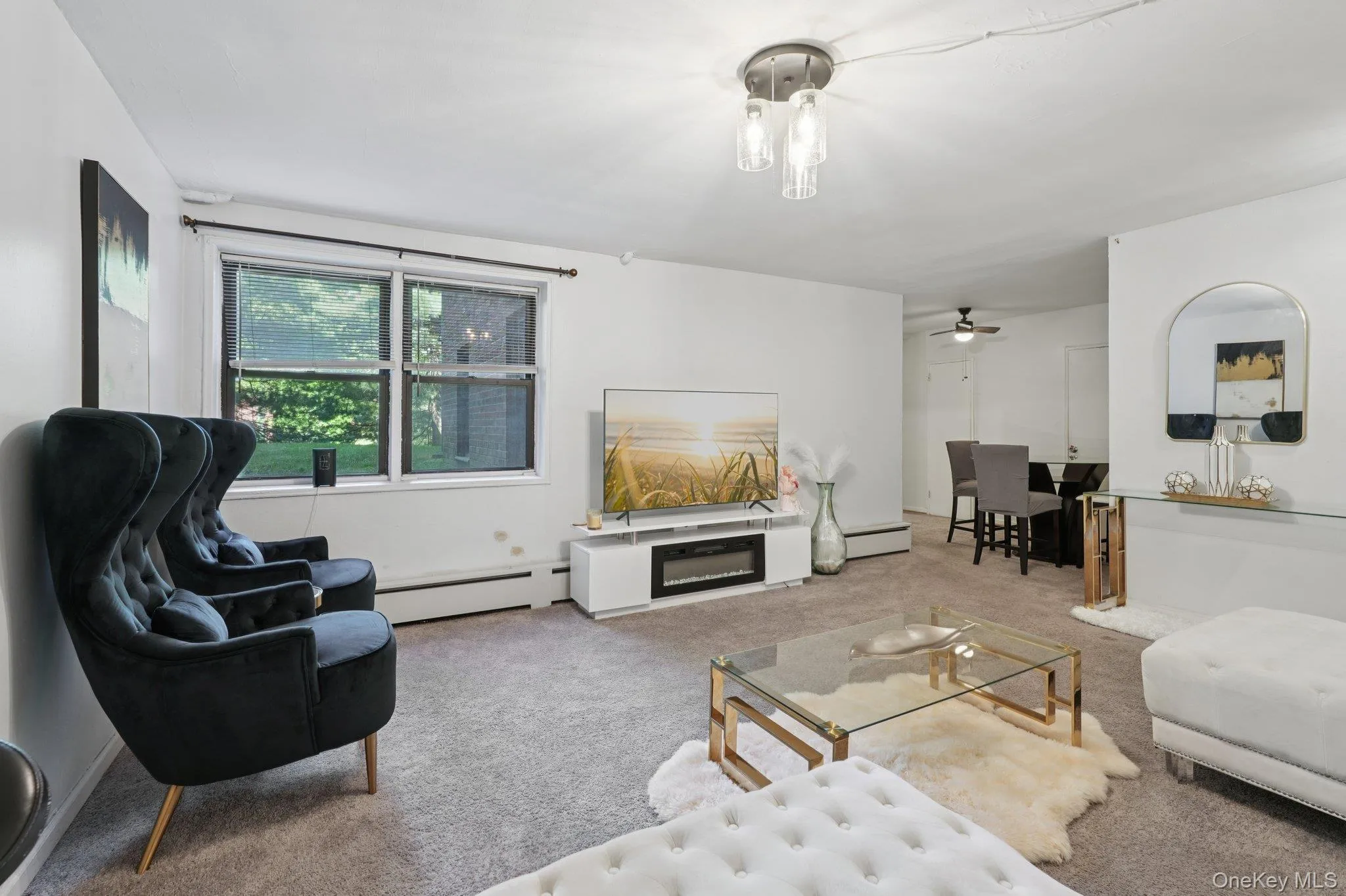 Carpeted living room featuring a baseboard radiator and ceiling fan Carpeted living room featuring a baseboard radiator and ceiling fan