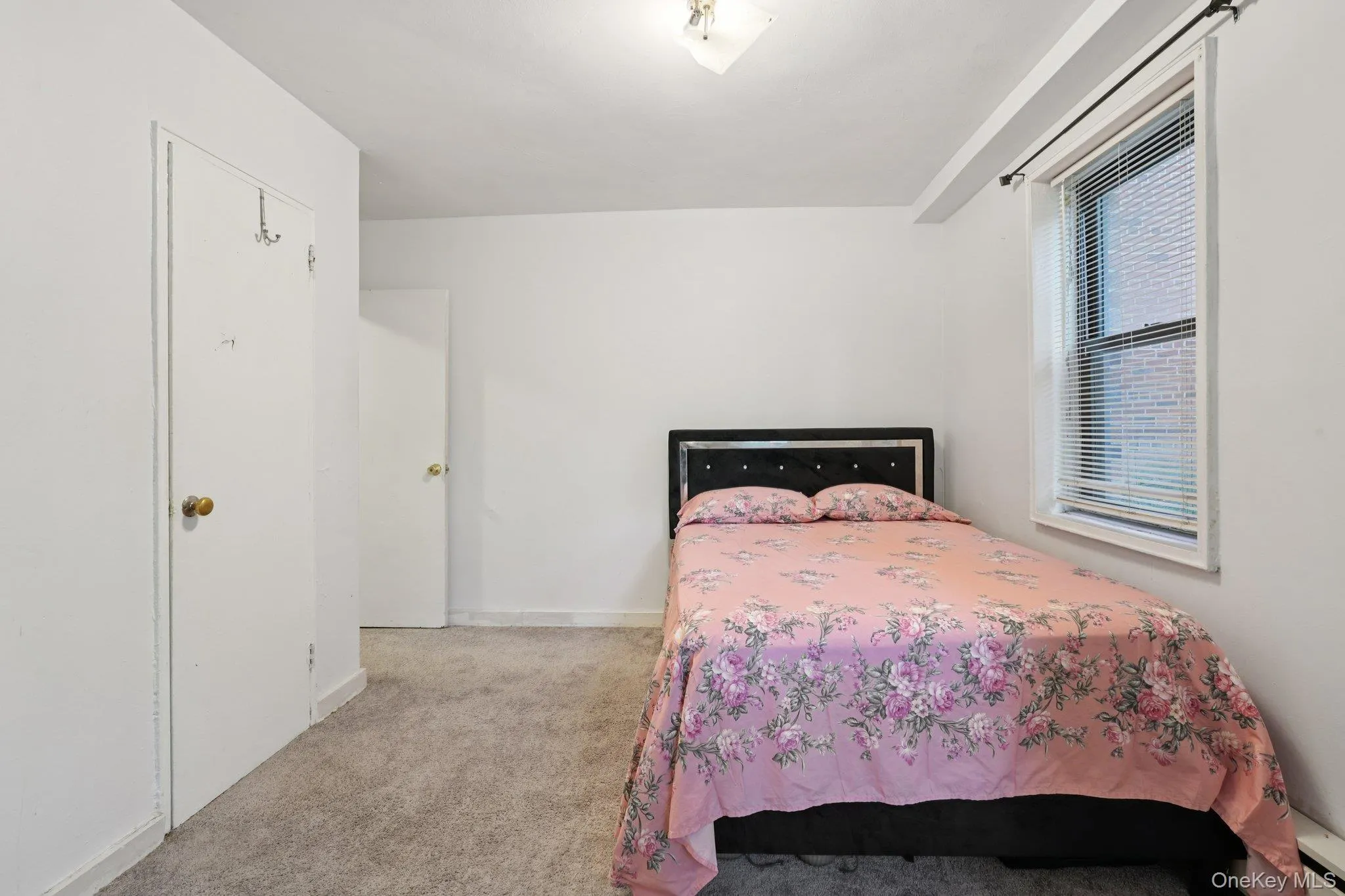 Bedroom with light colored carpet and baseboards Bedroom with light colored carpet and baseboards