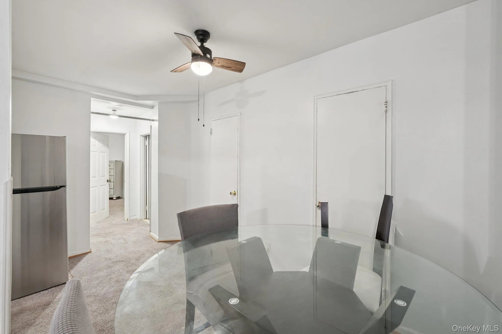 Dining room featuring light colored carpet and a ceiling fan Dining room featuring light colored carpet and a ceiling fan