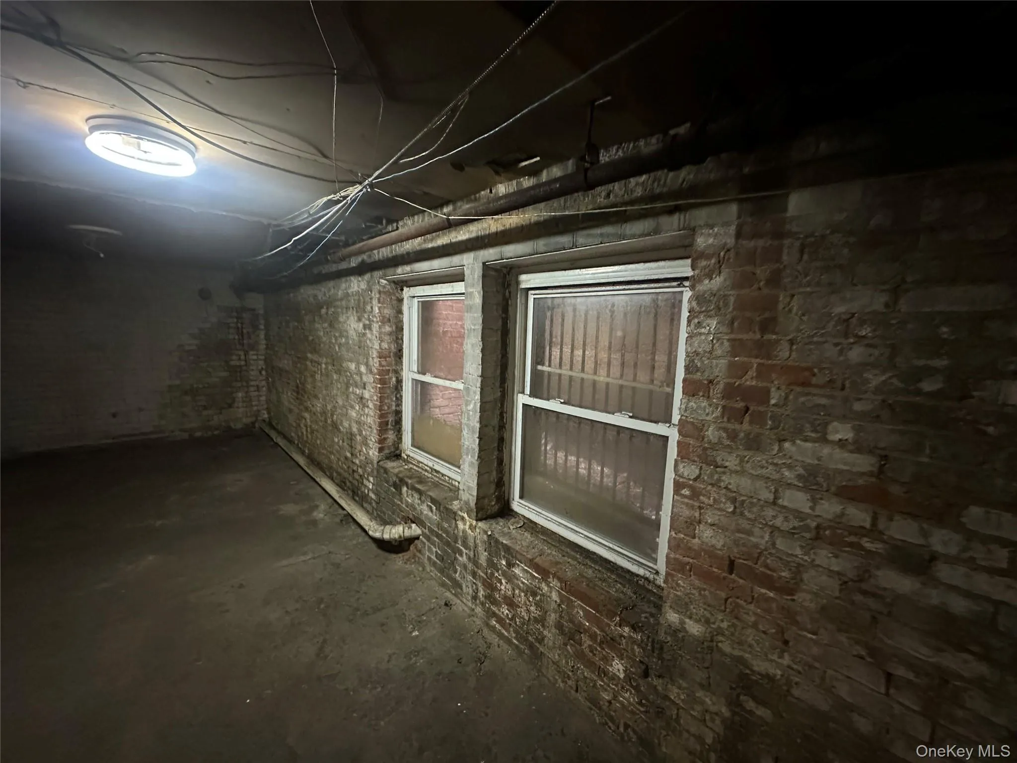 Unfinished below grade area featuring brick wall Unfinished below grade area featuring brick wall