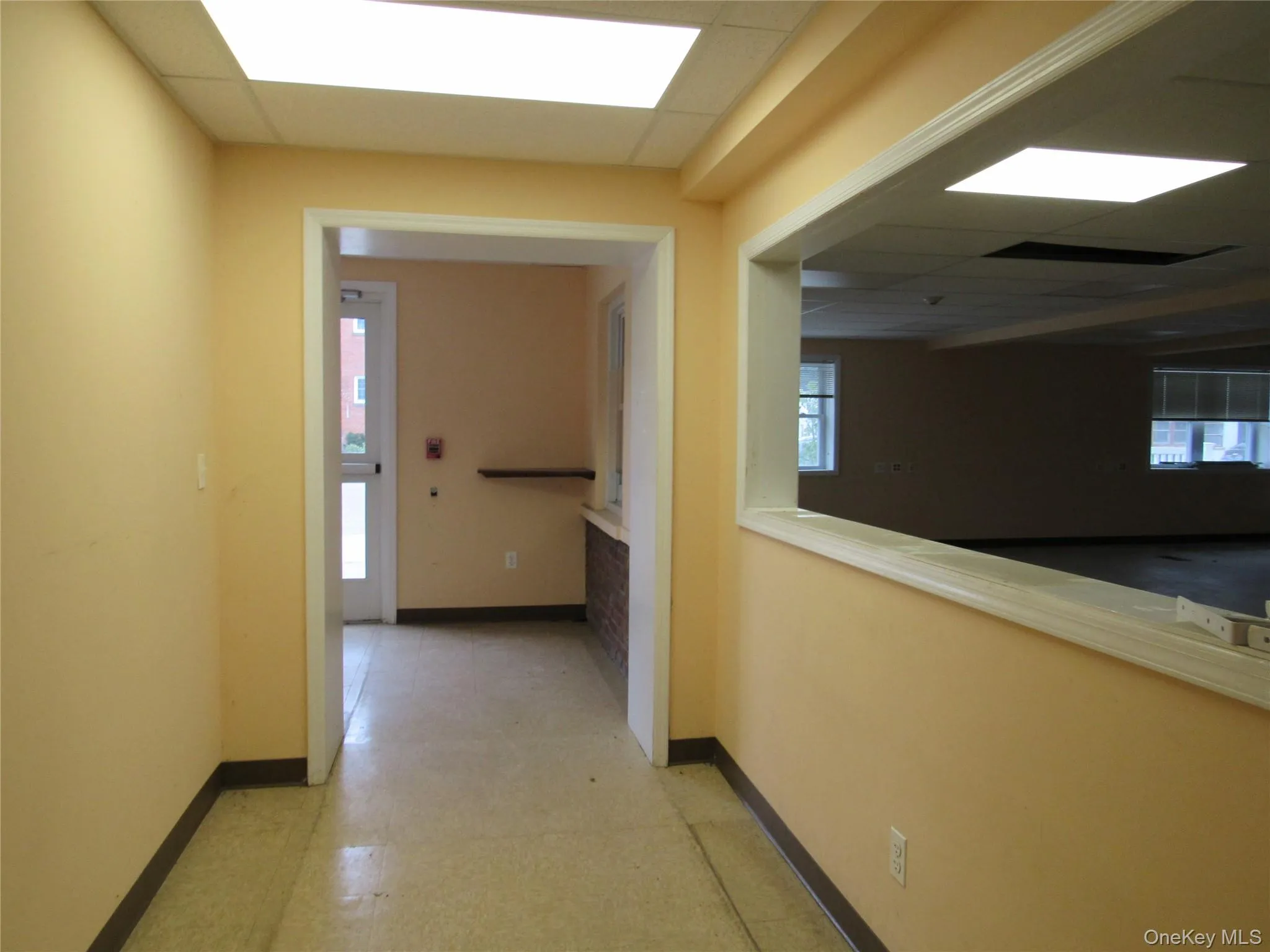 Hall featuring light floors and a drop ceiling Hall featuring light floors and a drop ceiling