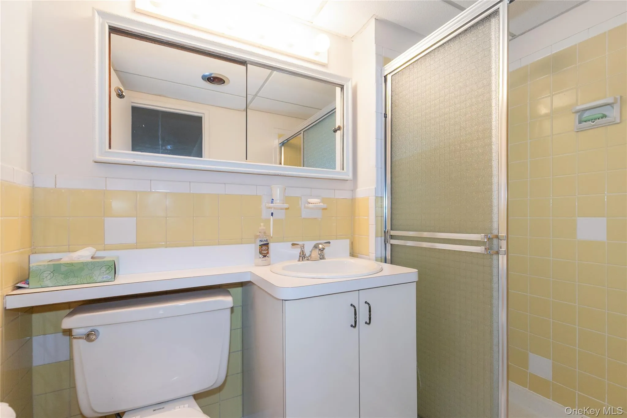 Bathroom with tile walls, a stall shower, vanity. Bathroom with tile walls, a stall shower, vanity.
