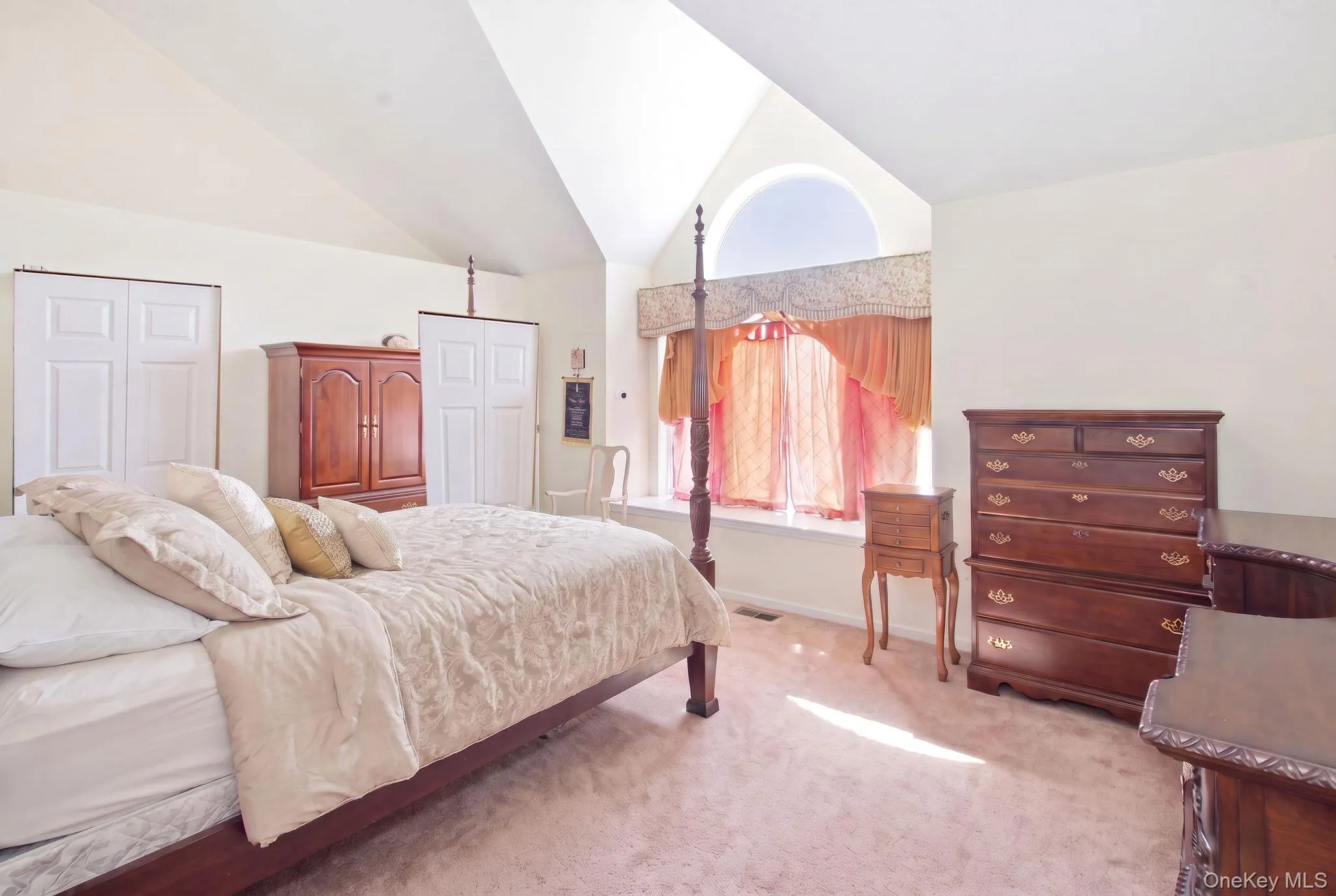 (Digitally decluttered) Sun pours across this spacious primary suite, with double closets along one wall and a window seat beneath the arch. (Digitally decluttered) Sun pours across this spacious primary suite, with double closets along one wall and a window seat beneath the arch.