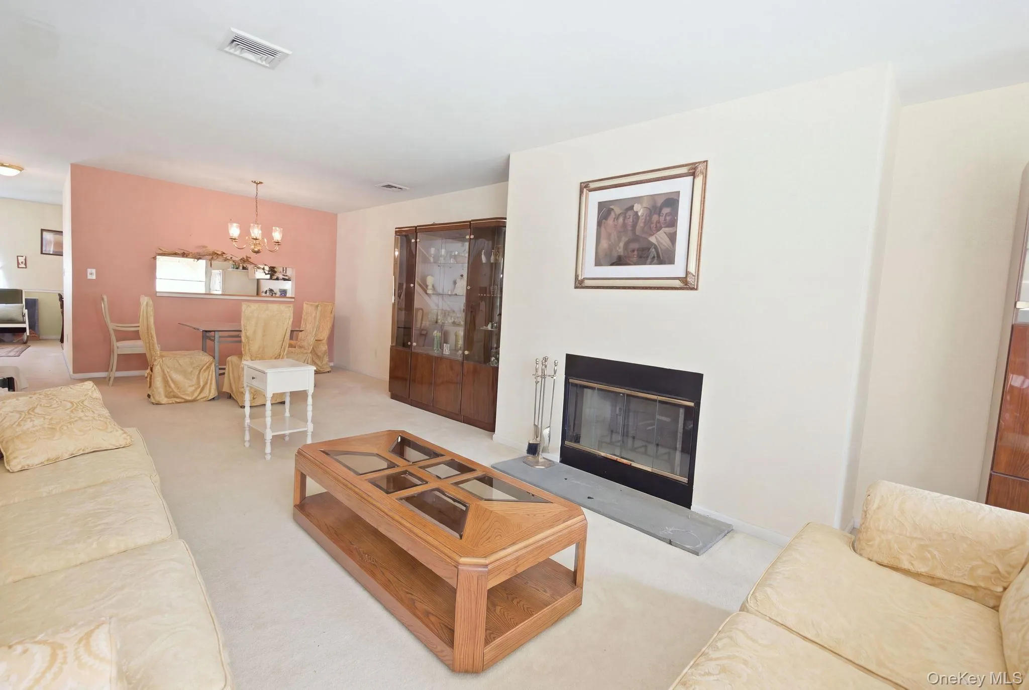 (Digitally decluttered) The fireplace anchors the living space, with the dining room and kitchen pass-through beyond. (Digitally decluttered) The fireplace anchors the living space, with the dining room and kitchen pass-through beyond.