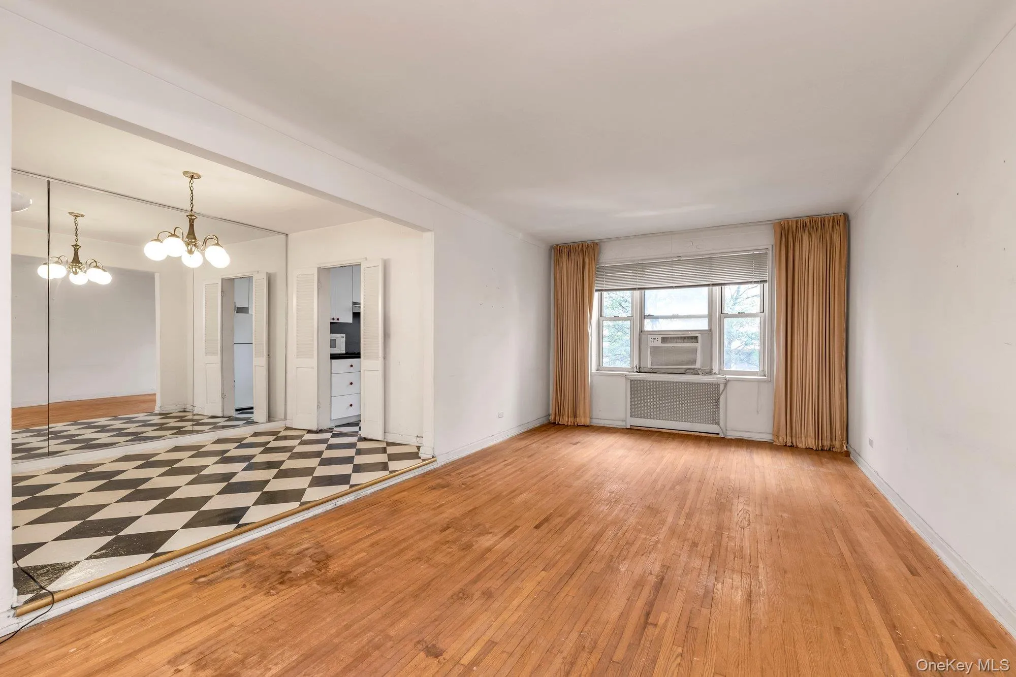 Unfurnished room with a chandelier and light wood-style flooring Unfurnished room with a chandelier and light wood-style flooring