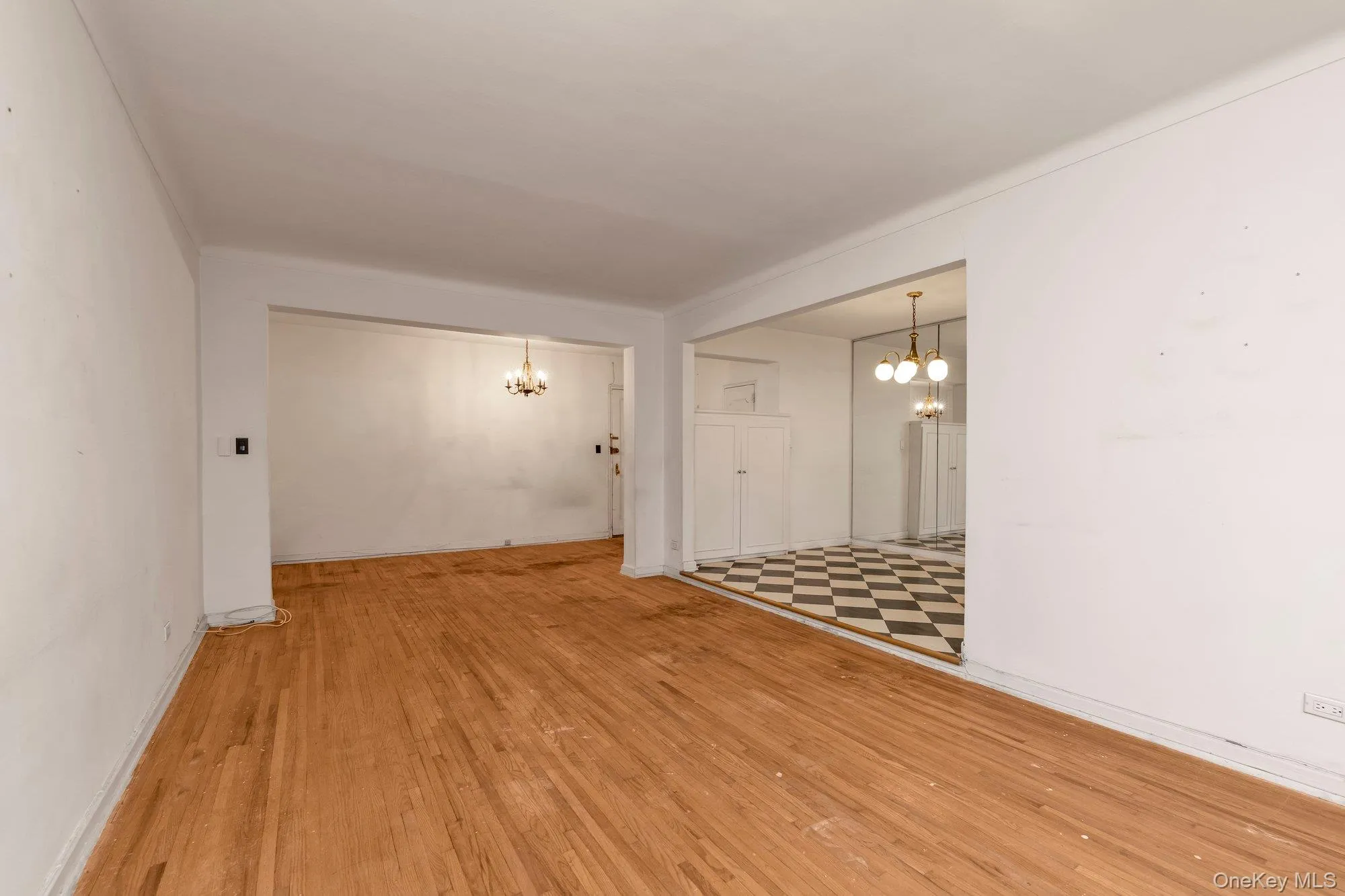 Empty room featuring a chandelier and light wood-style flooring Empty room featuring a chandelier and light wood-style flooring