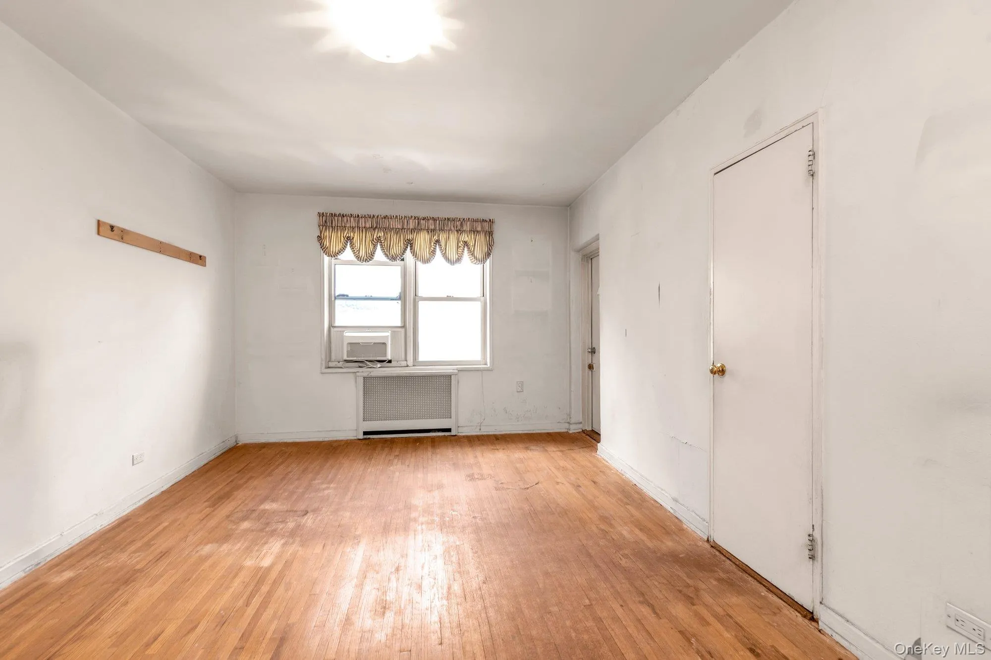 Unfurnished room with light wood finished floors and baseboards Unfurnished room with light wood finished floors and baseboards