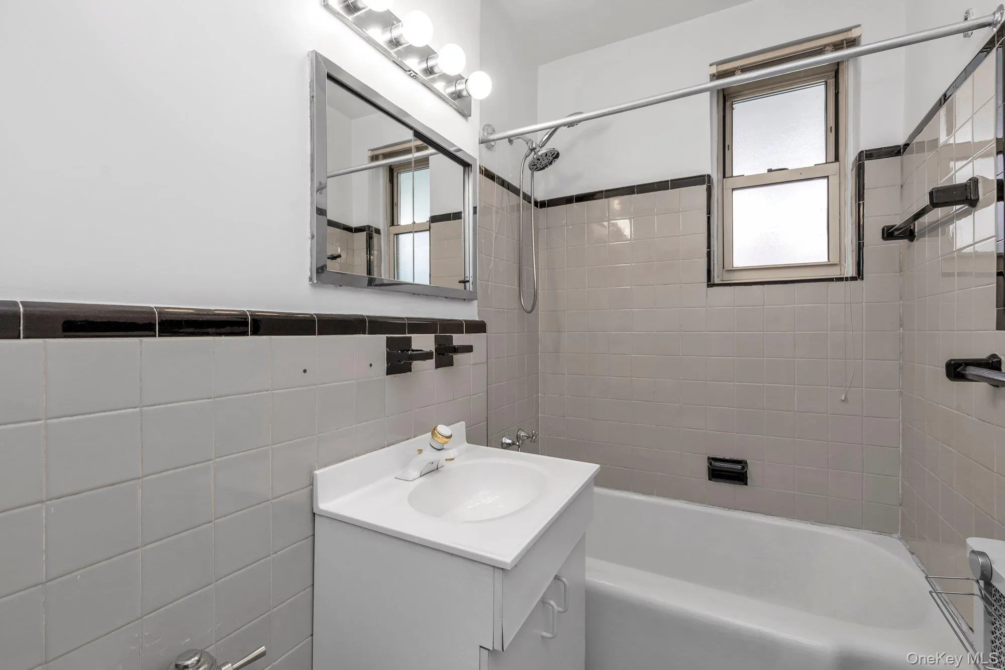 Full bath featuring shower combination, tile walls, and vanity Full bath featuring shower combination, tile walls, and vanity