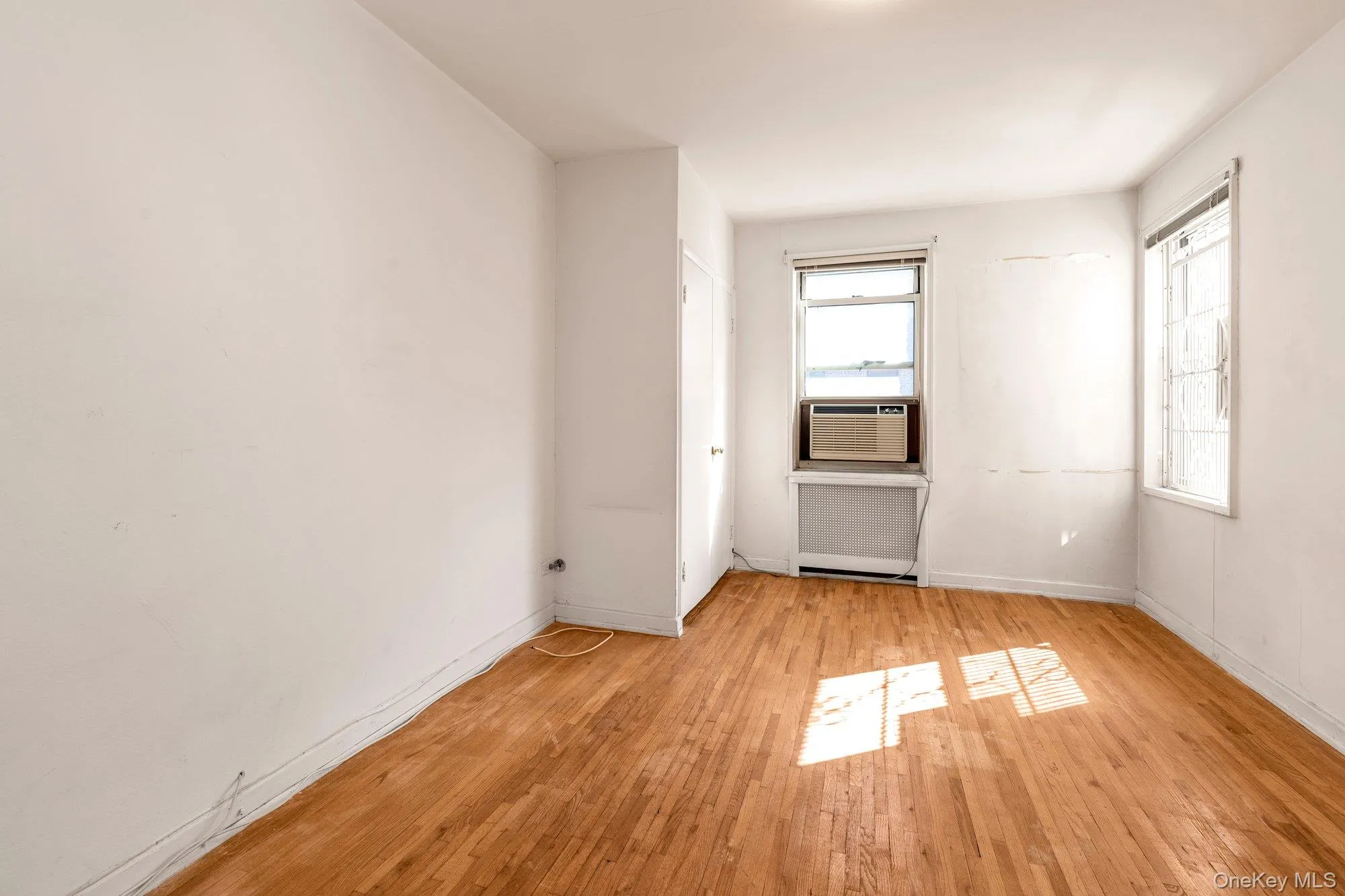 Spare room featuring light wood-style floors and radiator heating unit Spare room featuring light wood-style floors and radiator heating unit