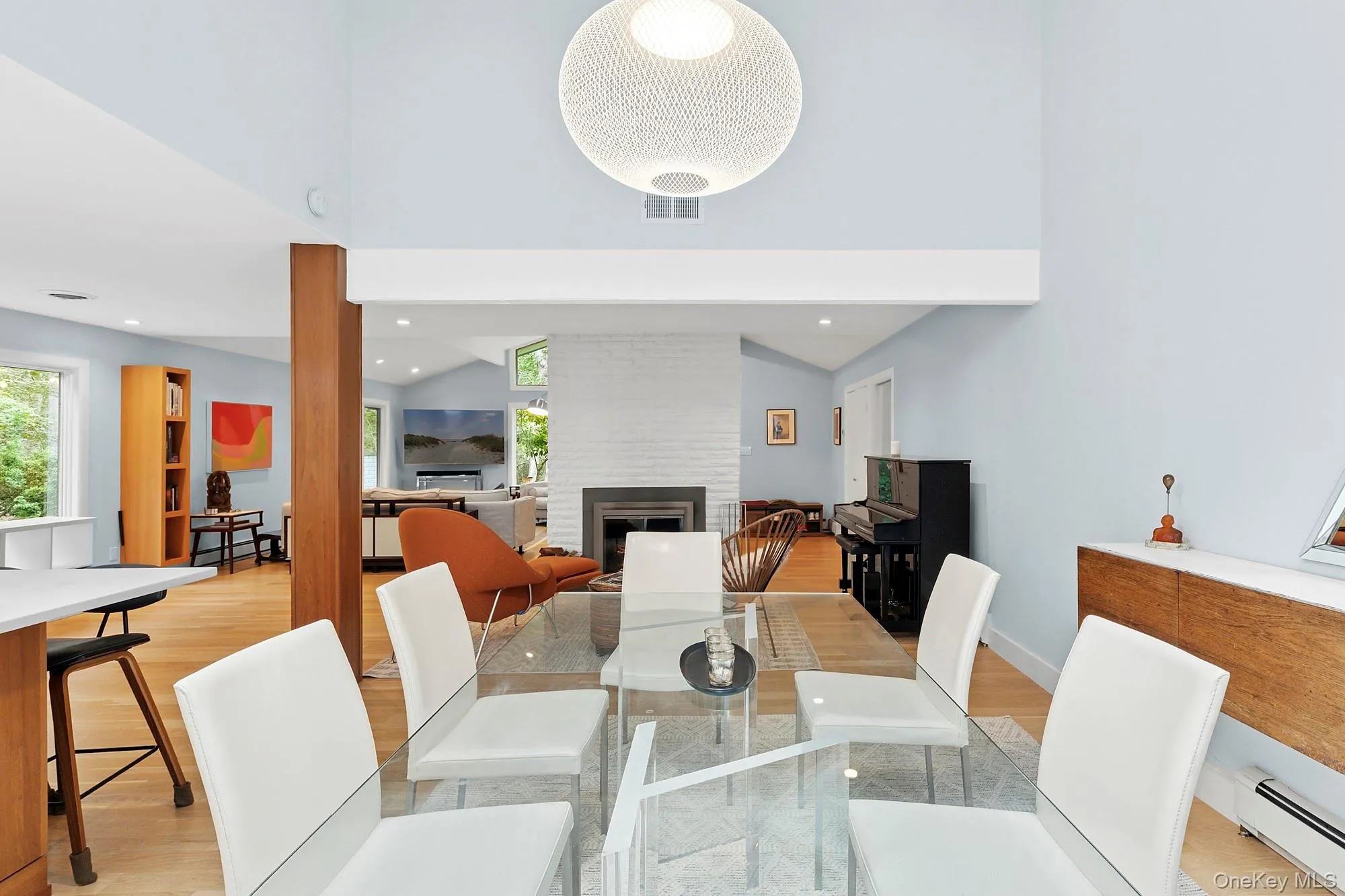 Dining area with light wood finished floors, a baseboard radiator, a fireplace, and recessed lighting Dining area with light wood finished floors, a baseboard radiator, a fireplace, and recessed lighting