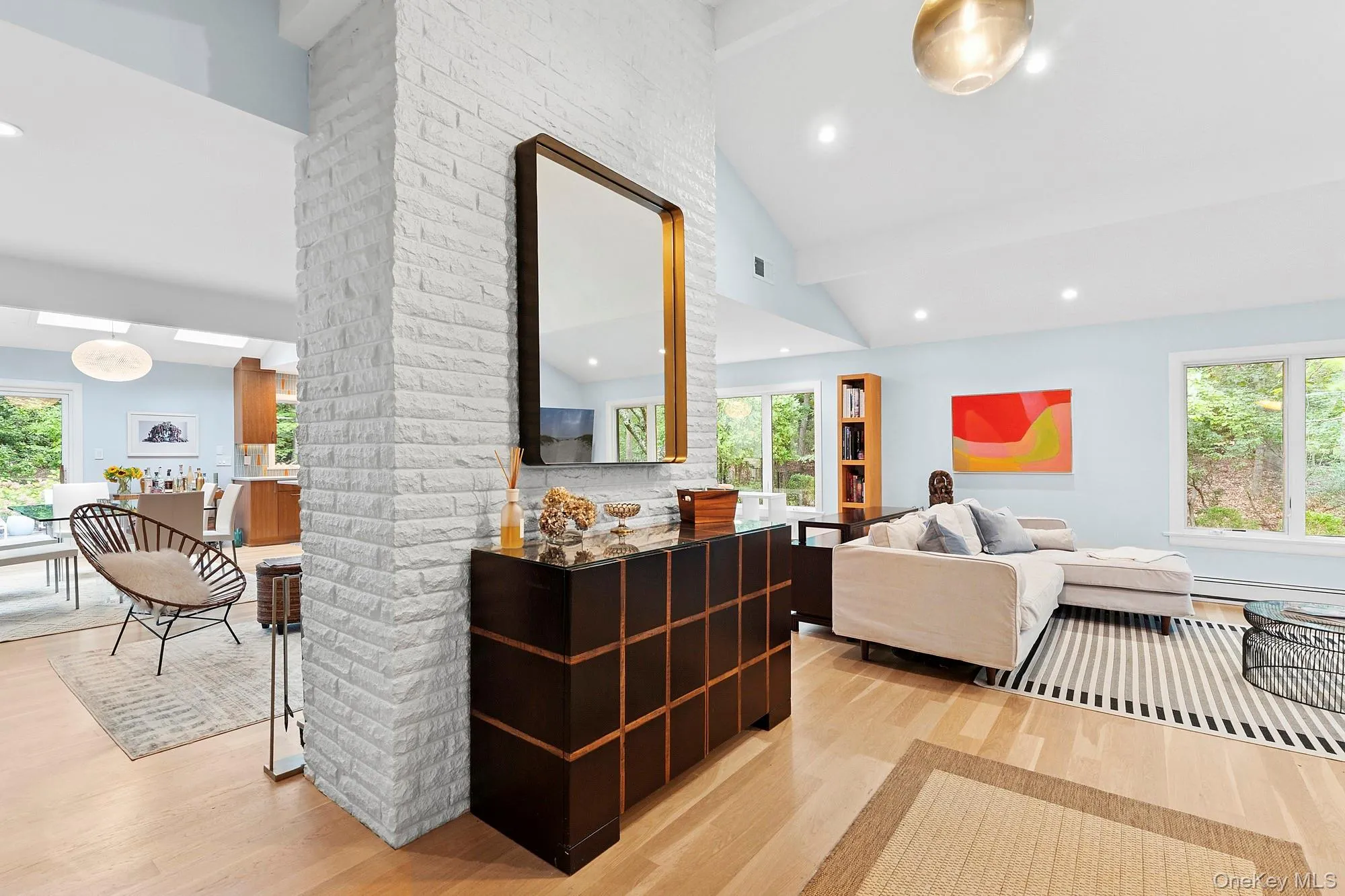 Living room featuring light wood-style flooring, high vaulted ceiling, and recessed lighting Living room featuring light wood-style flooring, high vaulted ceiling, and recessed lighting