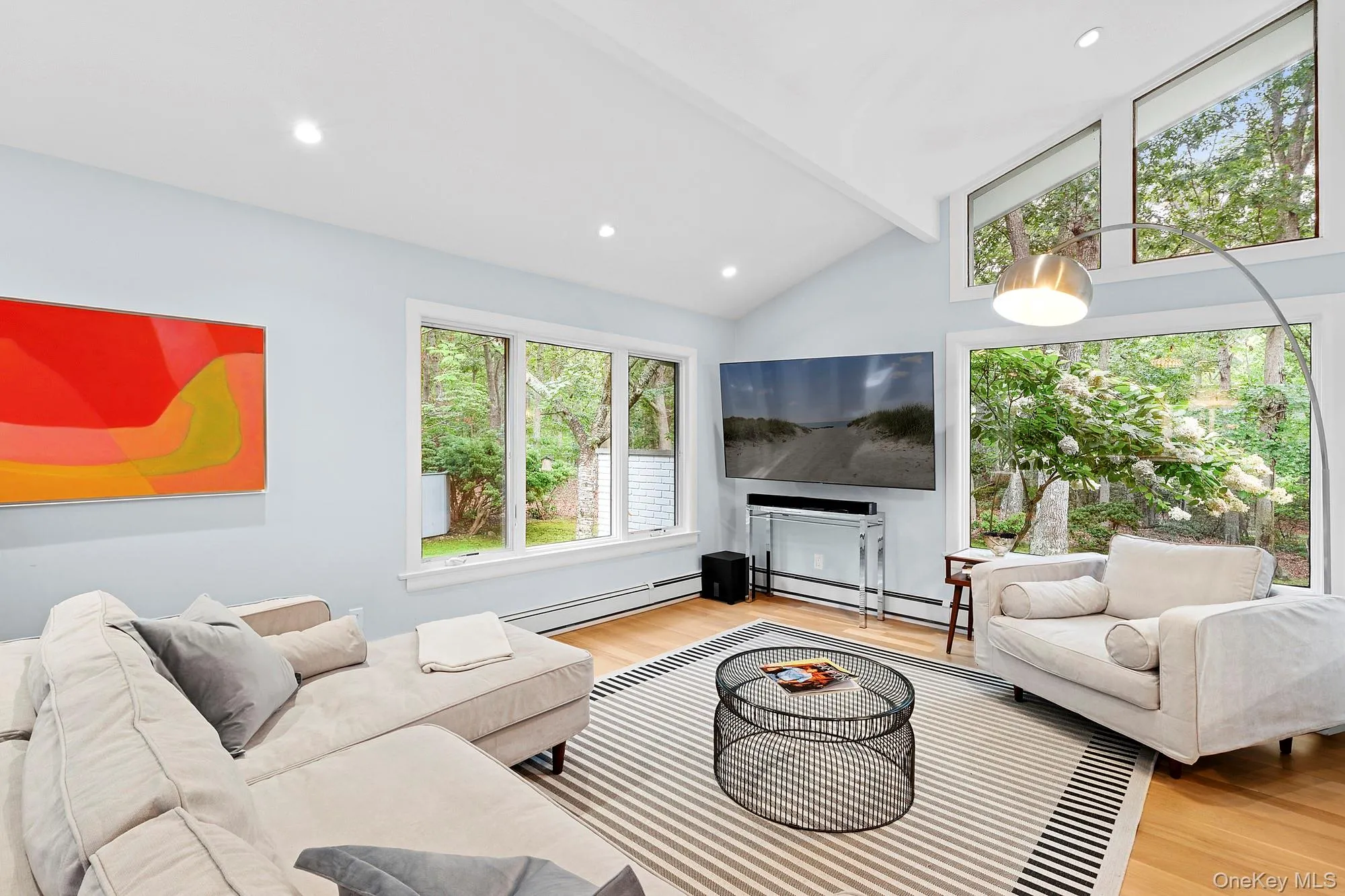 Living room with a baseboard heating unit, light wood-style flooring, and recessed lighting Living room with a baseboard heating unit, light wood-style flooring, and recessed lighting