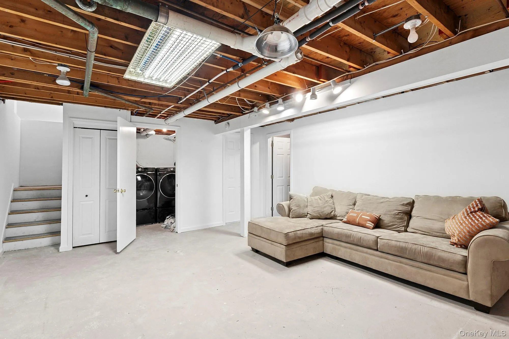 Finished basement featuring washing machine and dryer and stairway Finished basement featuring washing machine and dryer and stairway