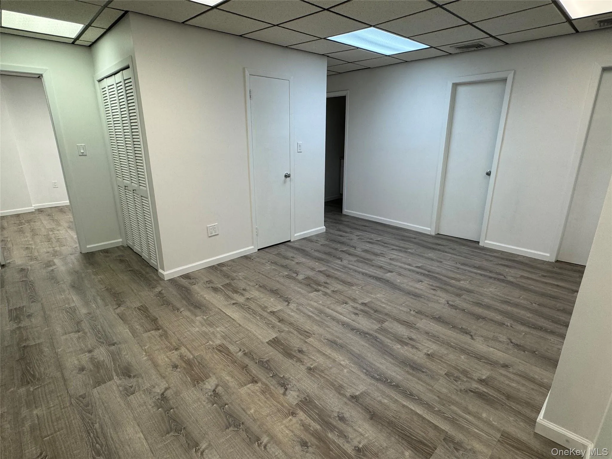 Basement with a drop ceiling and wood finished floors Basement with a drop ceiling and wood finished floors