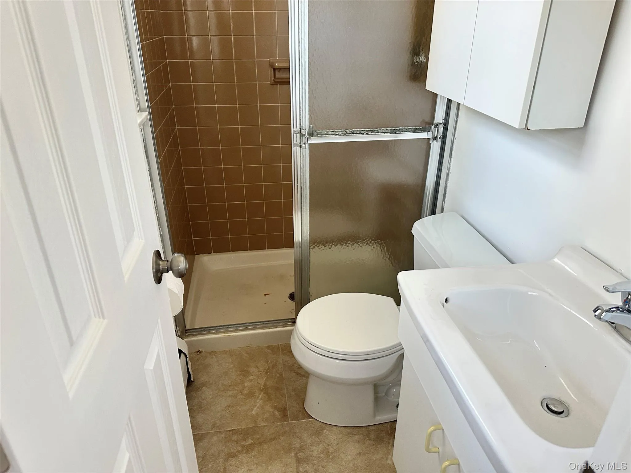 Bathroom with vanity, a shower stall, and light tile patterned floors Bathroom with vanity, a shower stall, and light tile patterned floors
