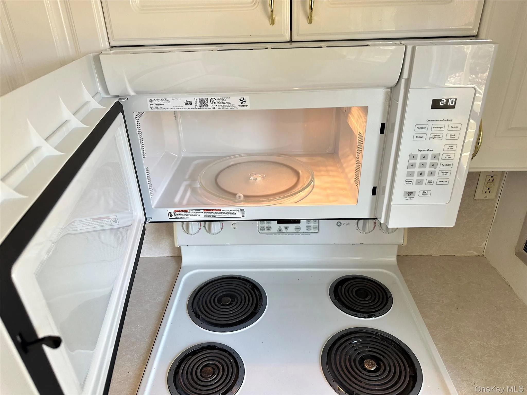 Kitchen view of white appliances, white cabinets, and light countertops Kitchen view of white appliances, white cabinets, and light countertops